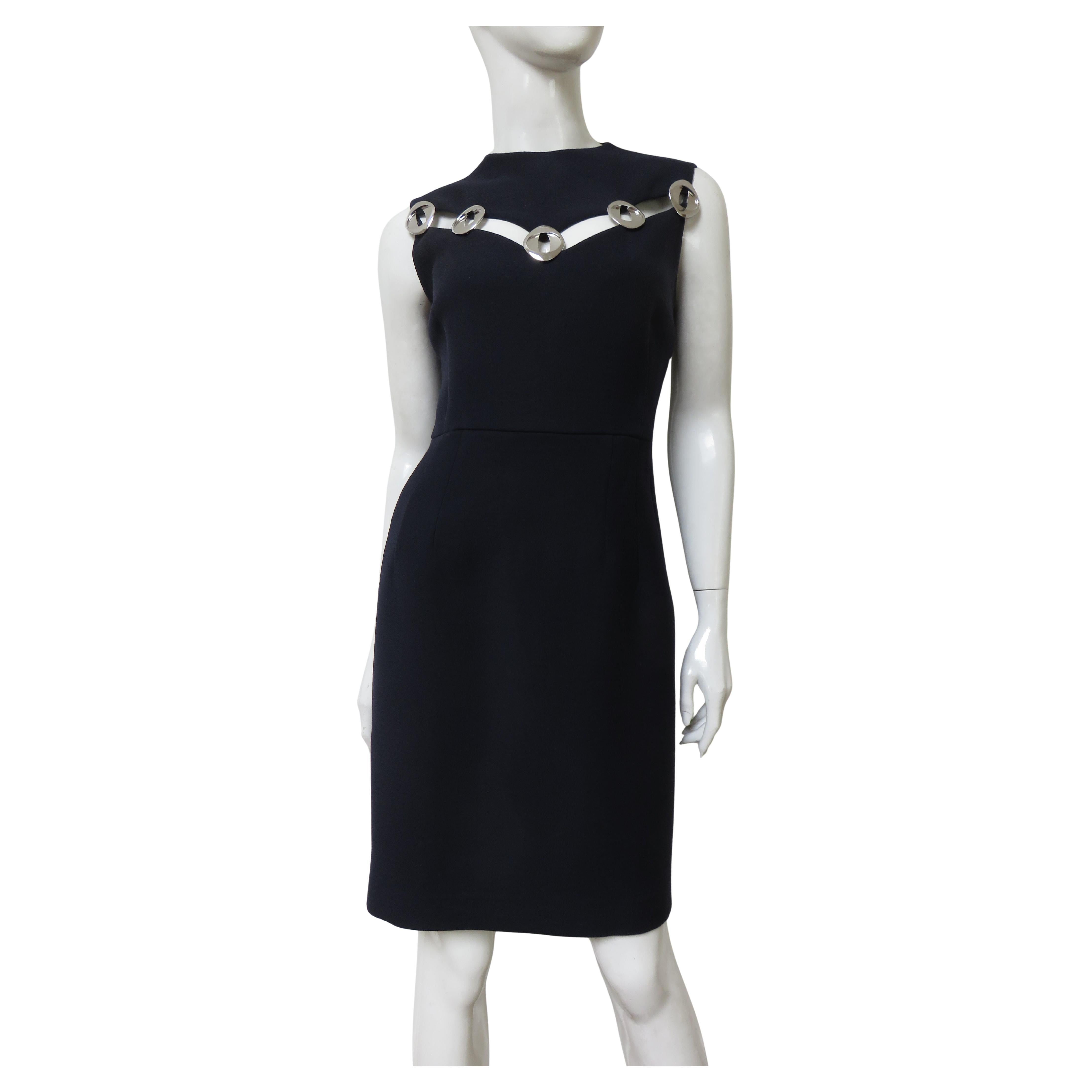 A fabulous Light weight navy silk/wool dress from Christian Dior.  It is a simple sleeveless semi fitted sheath with a V cut out above the bust joined together with 5 silver metal oval discs revealing a wedge of skin underneath.  It is lined in