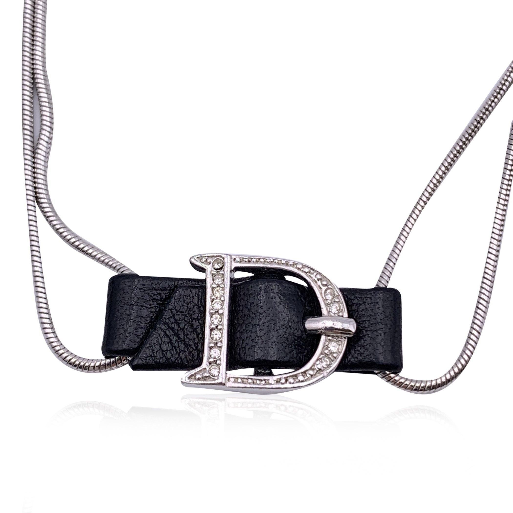Silver metal bracelet by CHRISTIAN DIOR.Black leather center piece with D buckle made with crystals. Lobster closure. Total length: 8.5 inches - 21.6 cm. Adjustable. CD small logo charm at the end of the bracelet. Condition A - EXCELLENT Gently