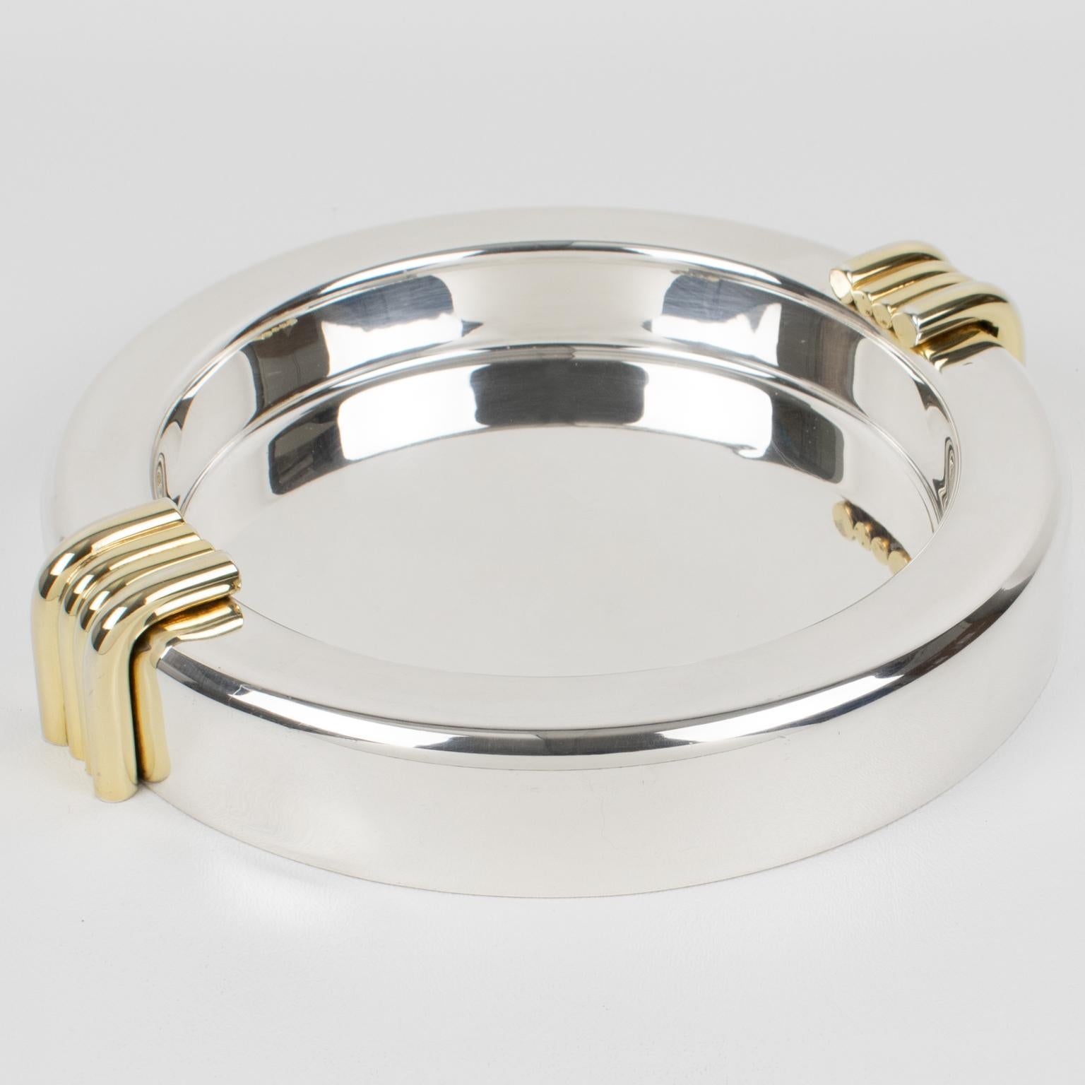 This elegant Christian Dior, Paris modernist large cigar ashtray or vide poche was crafted in France in the 1970s. This sophisticated silver plate catchall features an iconic streamlined design with clean lines and 24k gold-plated decorative raised
