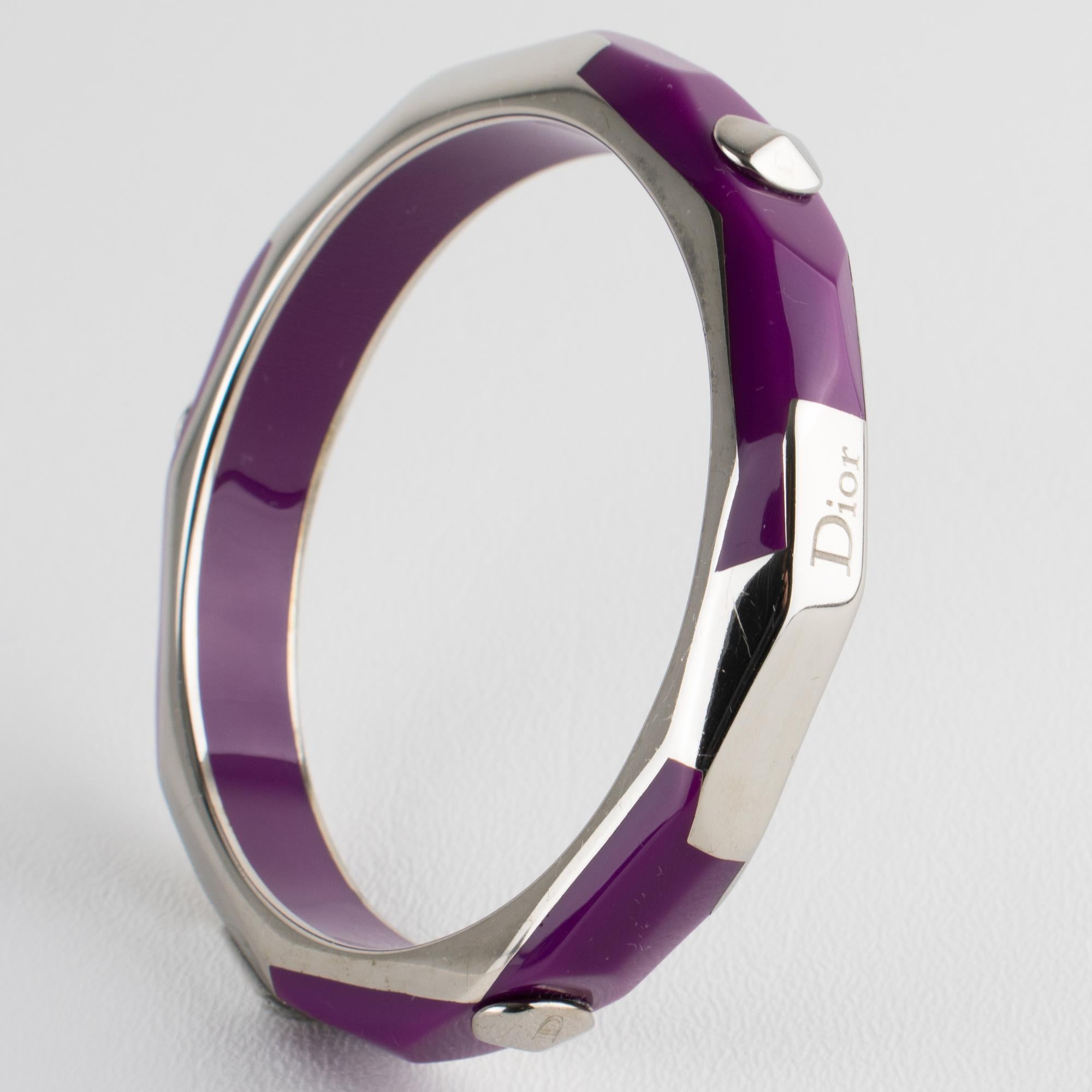Esta rara pulsera brazalete de Christian Dior es una pieza de resina acrílica (Lucite) y metal plateado con un marco de metal brillante de alto brillo, un motivo geométrico y elementos de resina de color púrpura ciruela. El brazalete lleva la