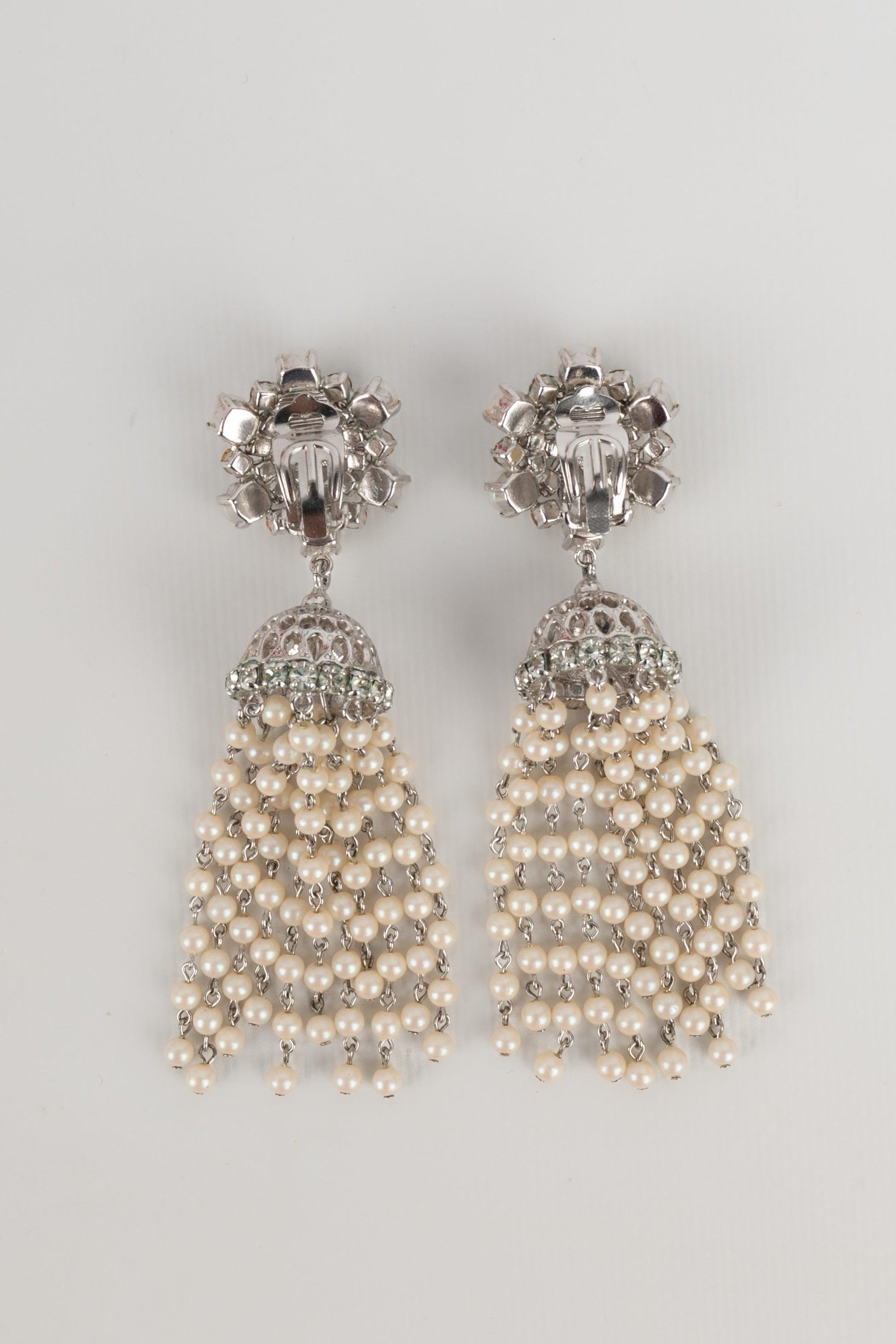 Dior - Silvery metal earrings ornamented with rhinestones holding a costume pearl pompom. 1970 Collection.

Additional information:
Condition: Very good condition
Dimensions: Height: 10 cm
Period: 20th Century

Seller Reference: BO160