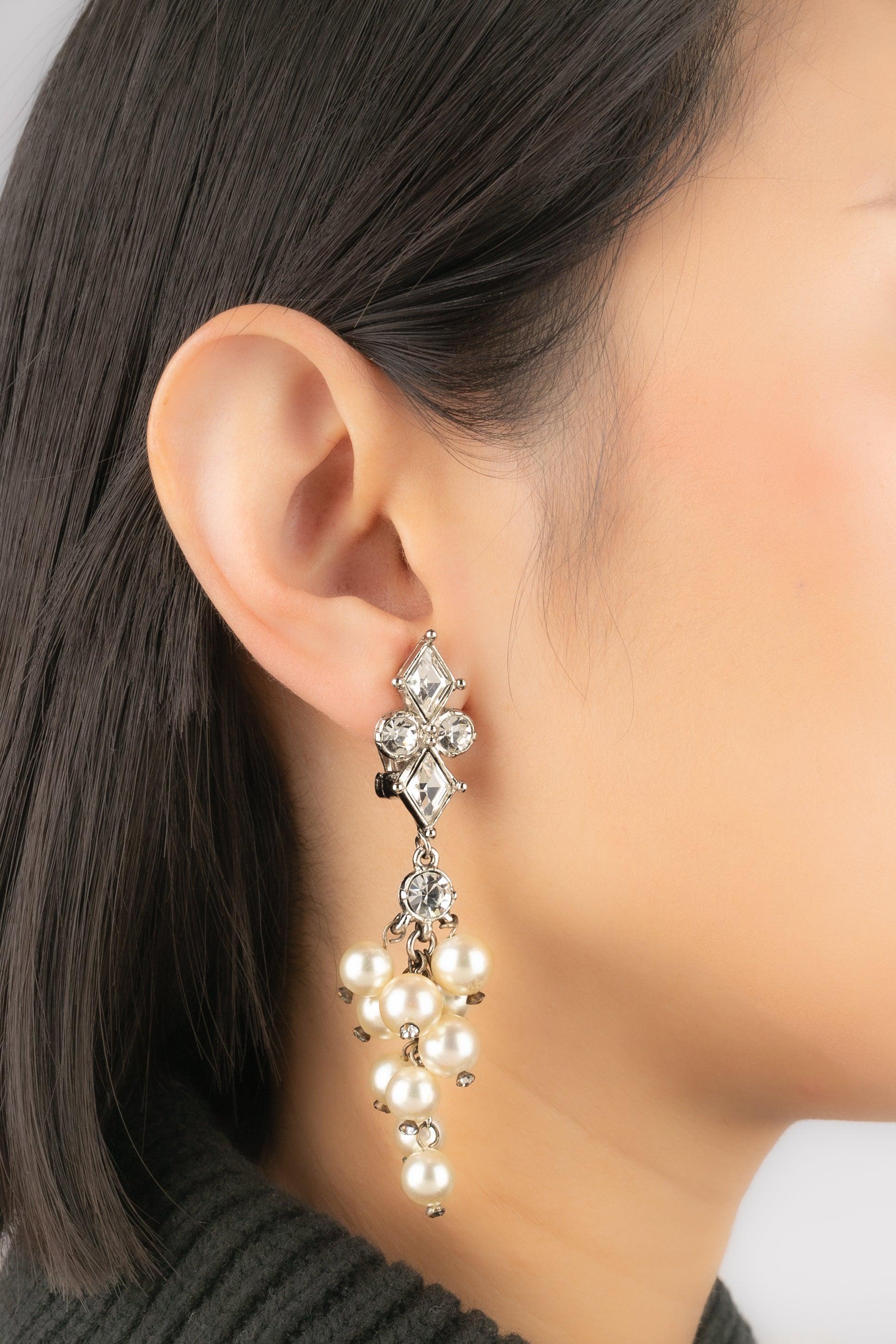 Dior - Orecchini in metallo argentato ornati da strass che reggono perle in costume con effetto a cascata.

Informazioni aggiuntive:
Condizioni: Ottime condizioni
Dimensioni: Altezza: 8 cm

Riferimento del venditore: BO390