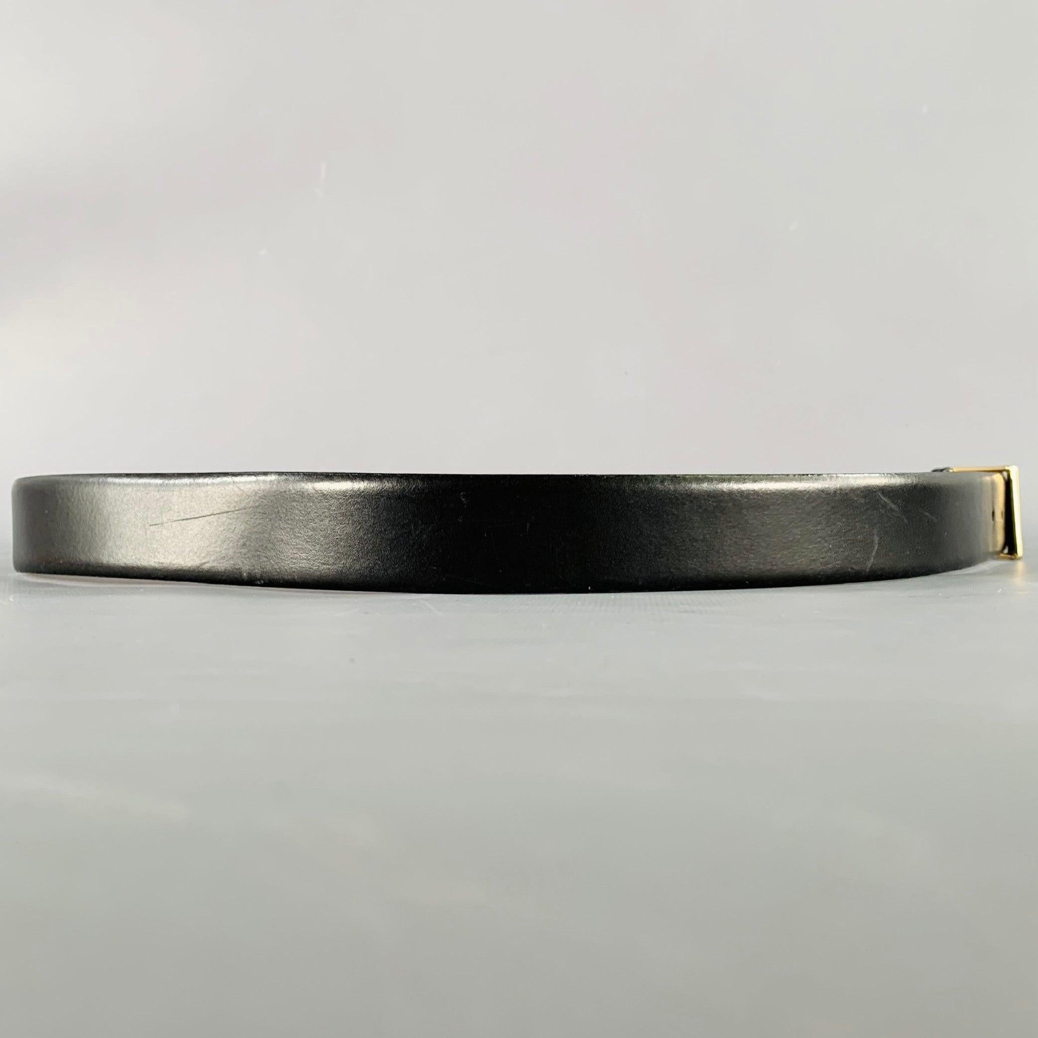 CHRISTIAN DIOR belt
in a black leather featuring a gold tone metal buckle with engraved monogram accent. Made in Spainches Very Good Pre-Owned Condition. Moderate signs of wear on inside of belt. 

Marked:   228873 01Length: 46 inches Width: 1