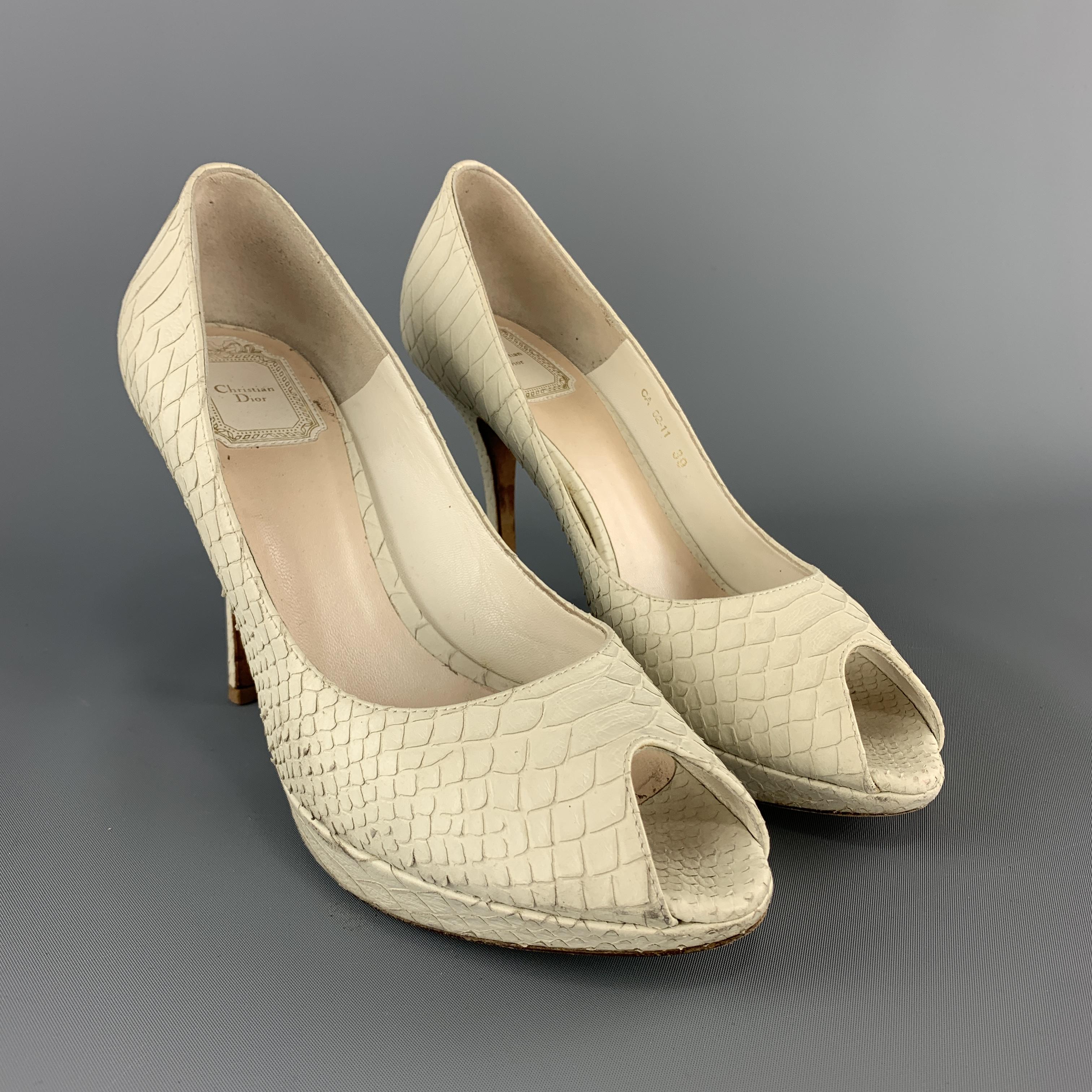 CHRISTIAN DIOR pumps come in cream snake skin leather with a peep toe, platform, and covered stiletto heel. Made in Italy.

Good Pre-Owned Condition.
Marked: IT 39

Heel: 4.25 in.
Platform: 1 in.