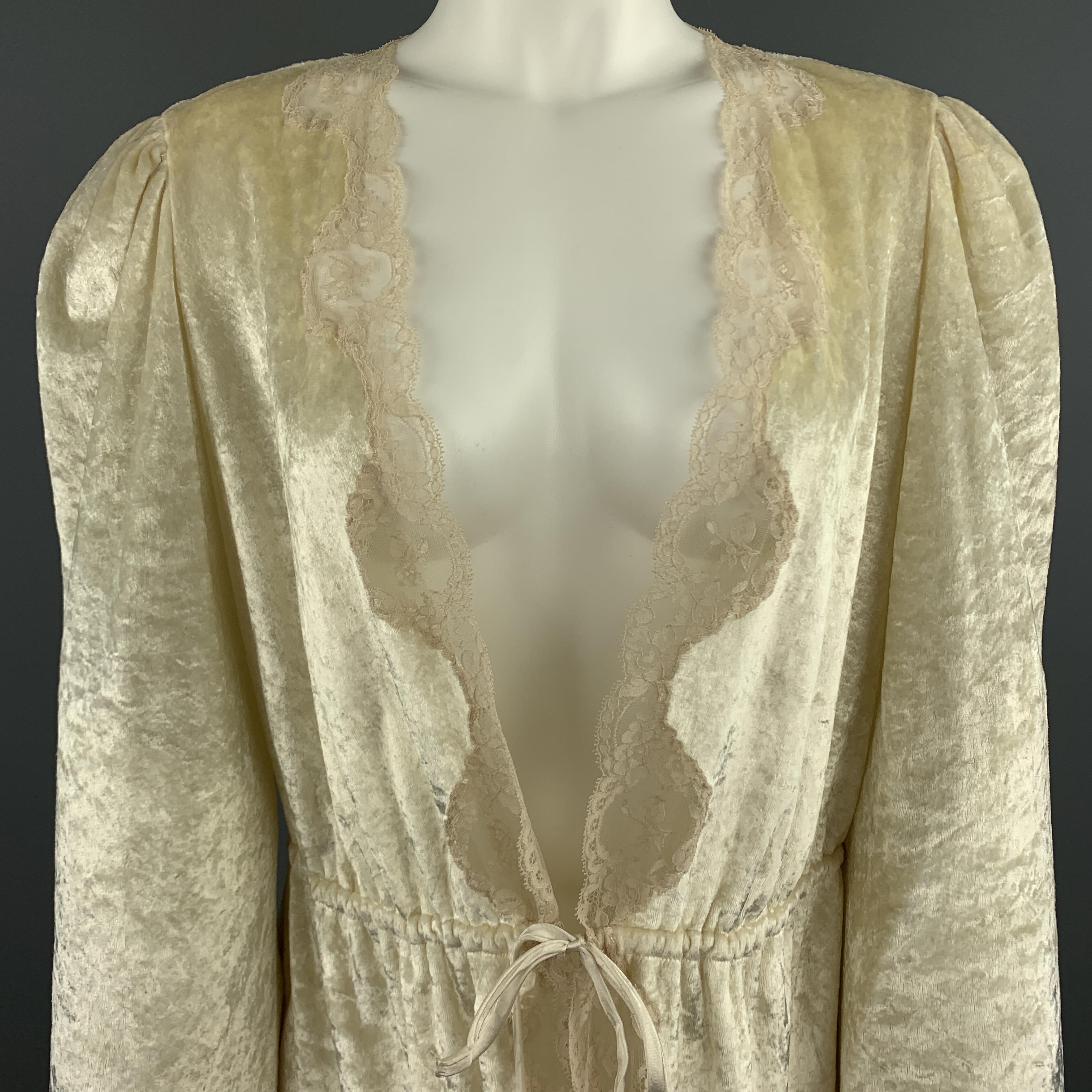 Vintage CHRISTIAN DIOR LINGERIE for I.MAGNIN robe top comes in cream crushed velvet with a deep V neck, drawstring waist tie closure, and beige lace trim. 

Very Good Pre-Owned Condition.
Marked:

Measurements:

Shoulder: 15 in.
Bust: 40 in.
Sleeve: