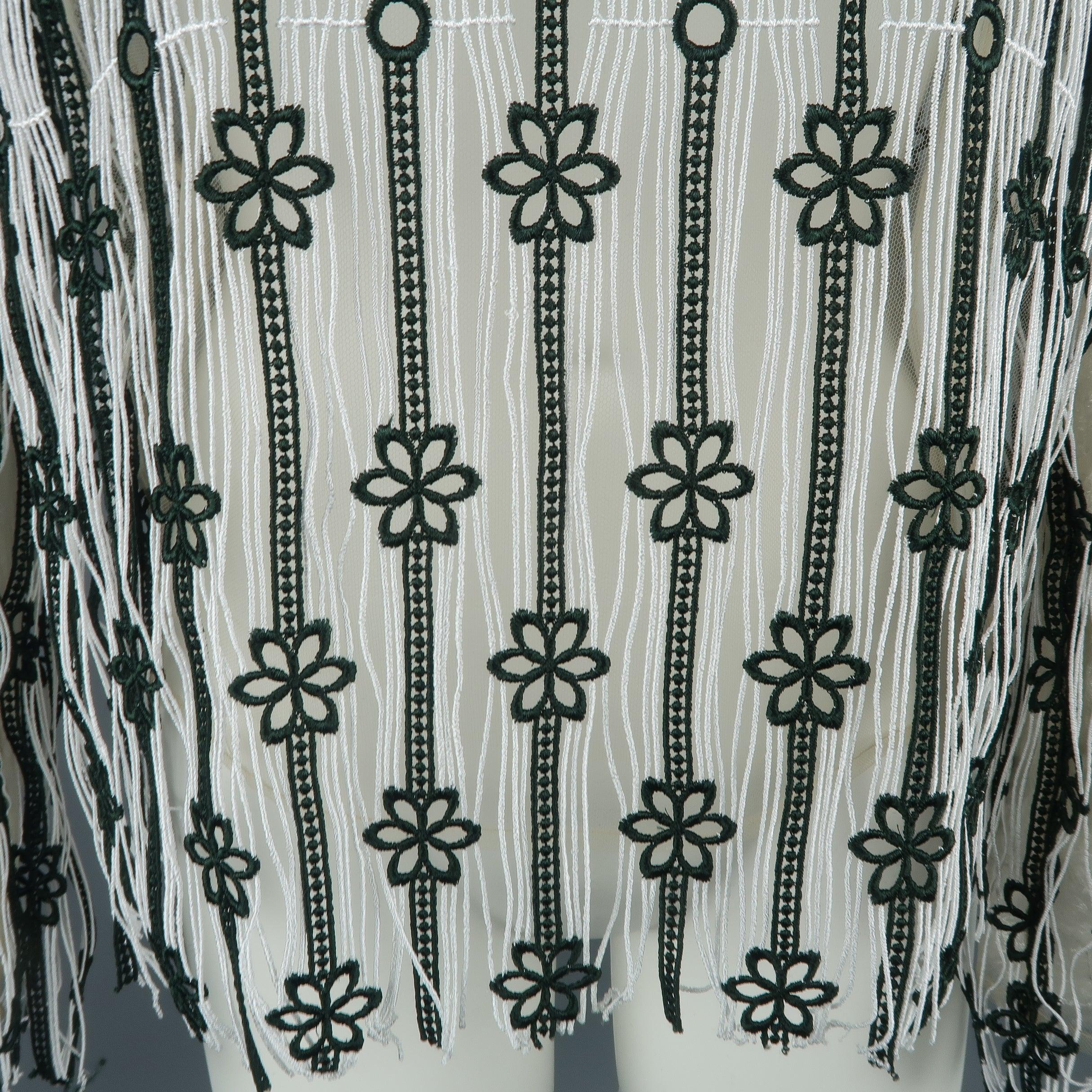 La blouse CHRISTIAN DIOR de la collection RESORT 2016 Palm Springs se présente en dentelle à franges rayée blanche et vert forêt avec accents floraux, et doublure en tulle stretch beige. Usure mineure et étiquettes enlevées. En l'état.
Bon état
