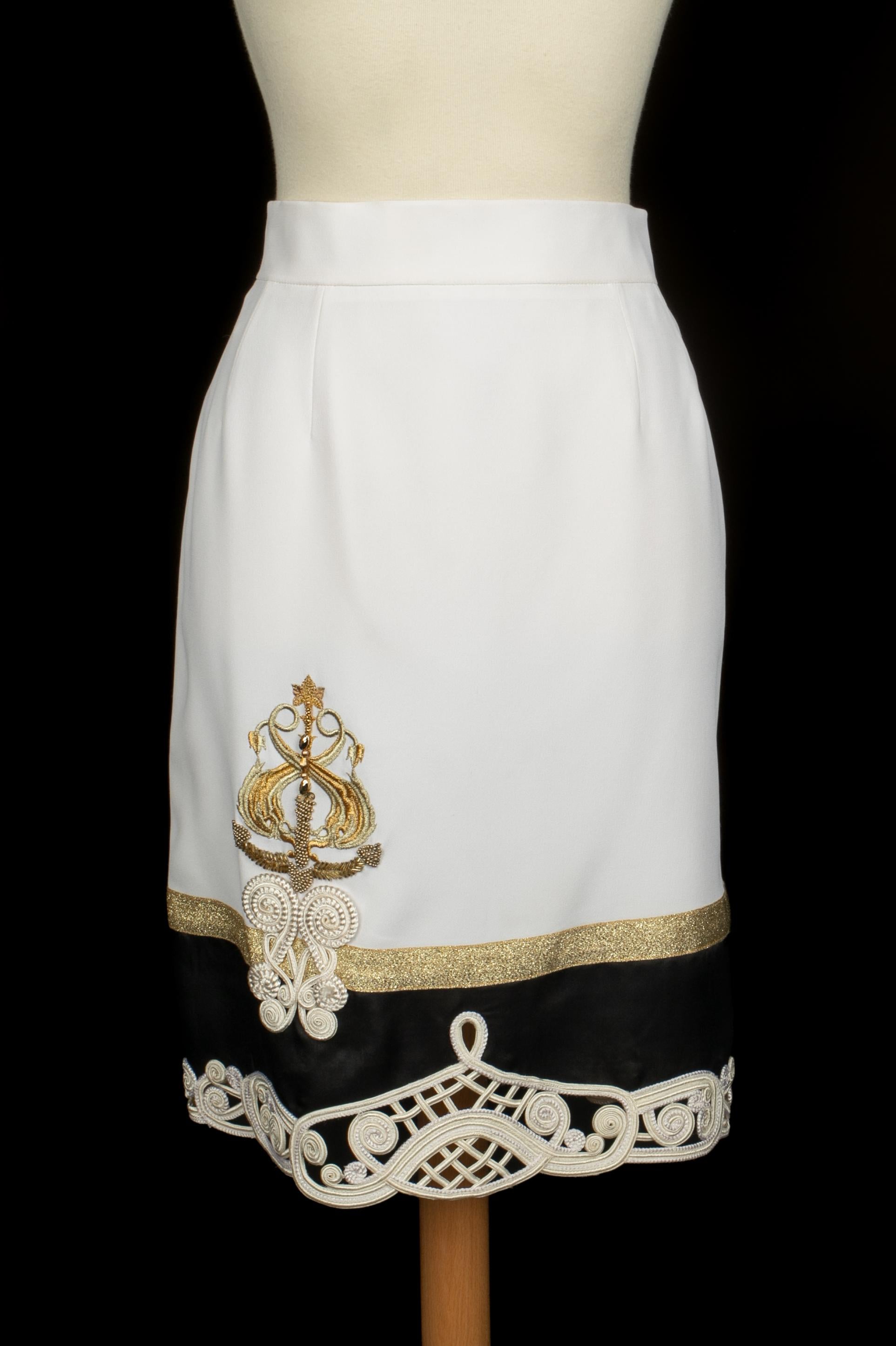 DIOR - (Made in France) Jupe mi-longue blanche avec une bande dorée et un bas de jupe noir bordé de passementeries blanches et de broderies dorées. Taille 42FR indiquée. A Collectional circa 1990 sous la Direction artistique de Gianfranco