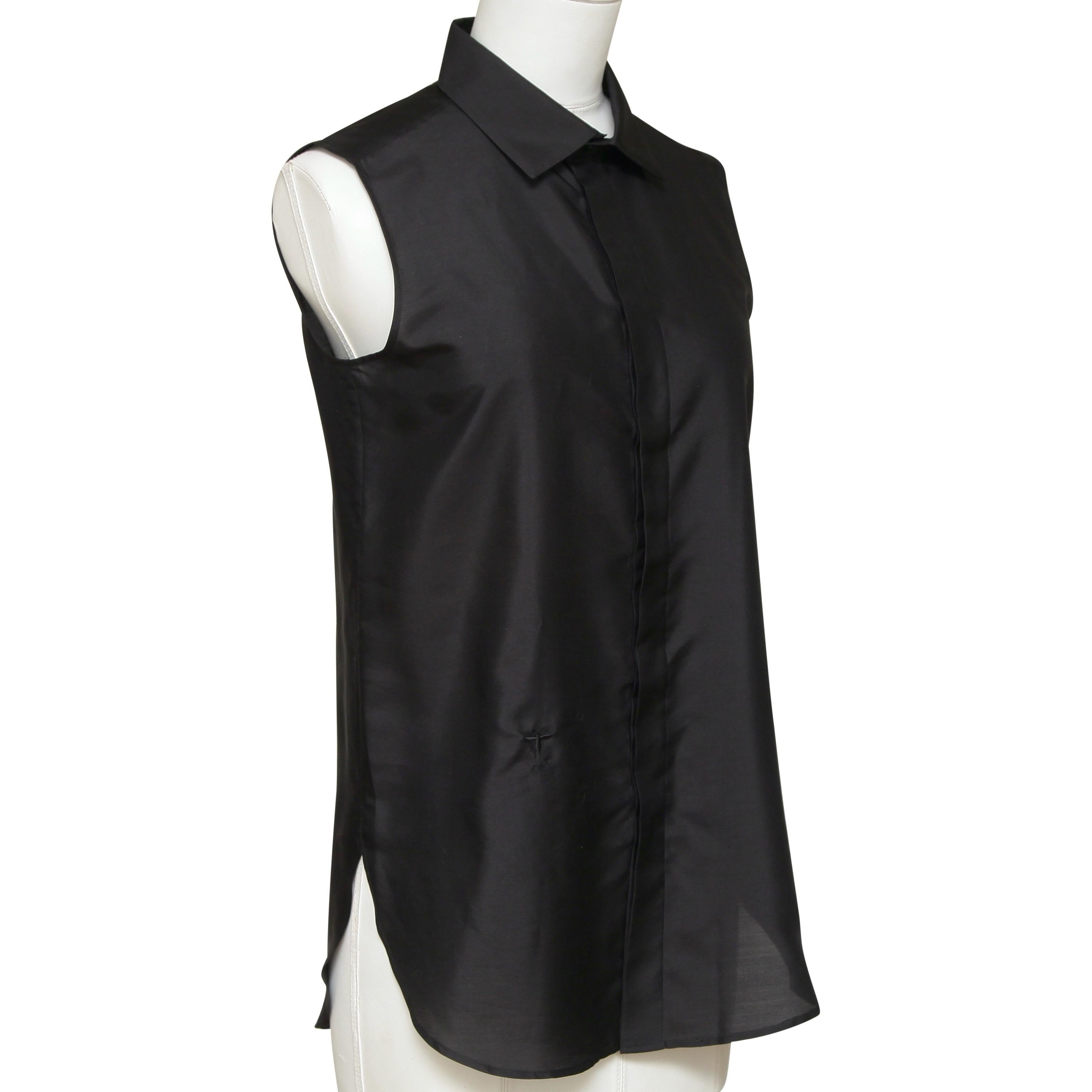 GUARANTEED AUTHENTIC CHRISTIAN DIOR BLACK SLEEVELESS SILK BLOUSE

Design:
- Sleeveless black silk blouse.
- Pointed collar.
- Covered button down front.
- Logo at lower right hip.

Material: 100% Silk

Size: F 36, US 4

Measurements (Approximate