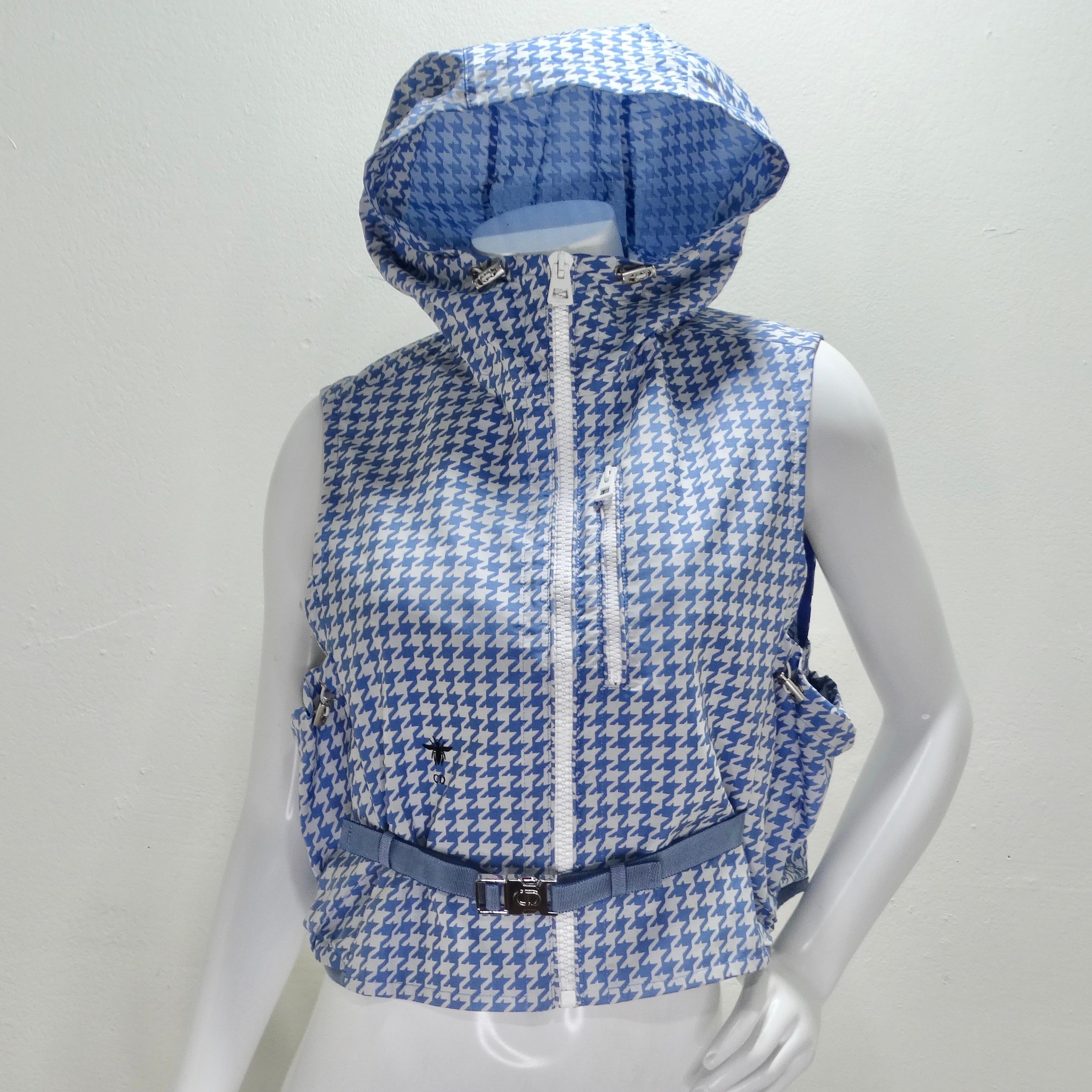 Introducing the Christian Dior Sleeveless Hooded Vest in White & Blue Houndstooth from the Cruise 2022 Collection by Maria Grazia Chiuri. This striking piece features a sports-inspired design that combines functionality with high fashion.

Crafted