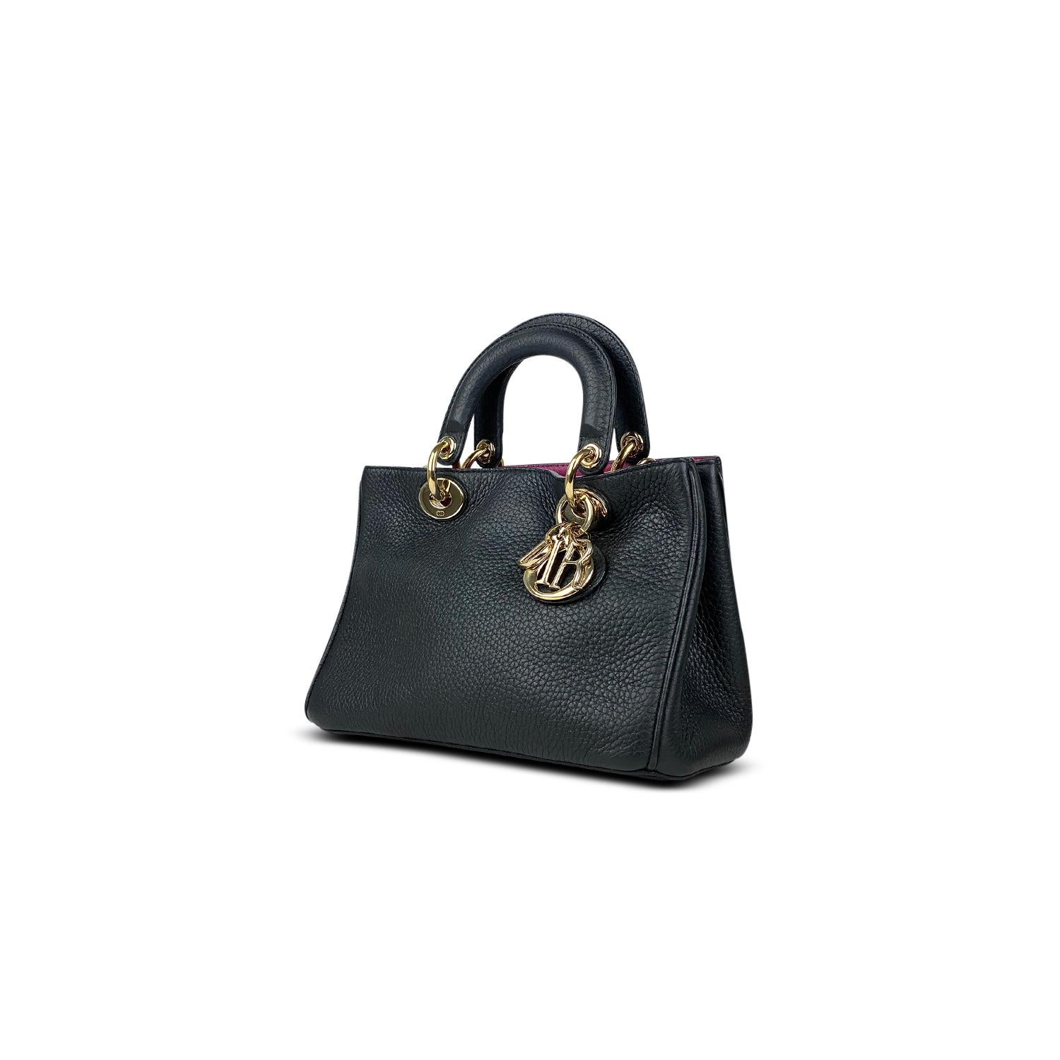 Black grained leather Christian Dior Small Diorissimo bag with

– Gold-tone hardware
– Convertible chain-link and leather shoulder strap
– Dual flat top handles featuring monogram logo charms
– Single detachable flat shoulder strap
– Protective feet