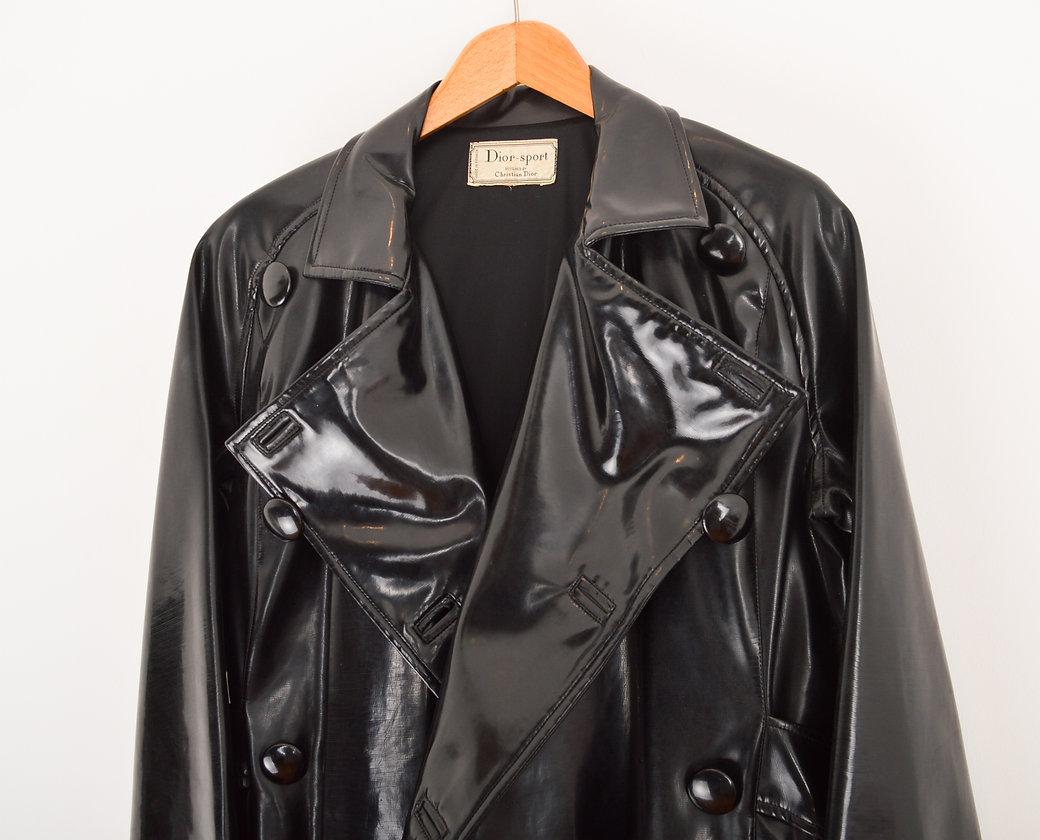 Schwarzer Lackmantel in Kokonform aus den 1950er Jahren für das Label Dior-Sport. Mit einer zentralen Knopfleiste und einem losen Gürtel mit Verzierungen auf der Rückseite.
 
Merkmale;
Expedit 32 Paris