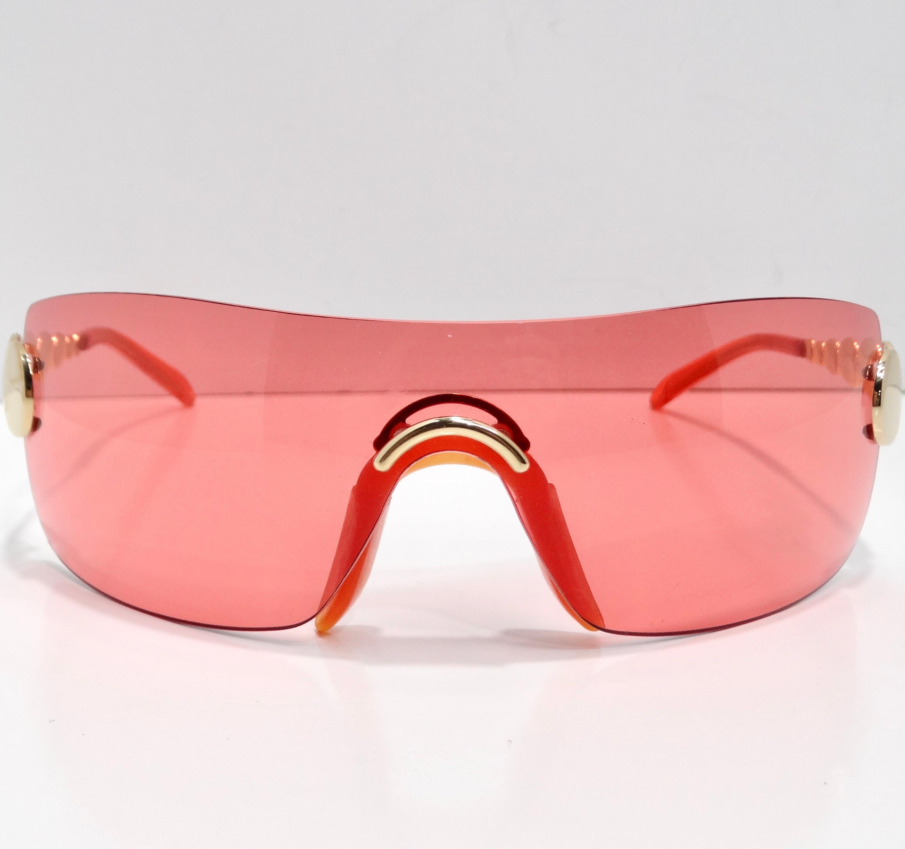 Experience unparalleled elegance with the Christian Dior Spring 2004 Galliano Red Mask Sunglasses, a stunning fusion of avant-garde design and timeless sophistication. These extraordinary mask-style sunglasses are adorned with red rimless lenses,