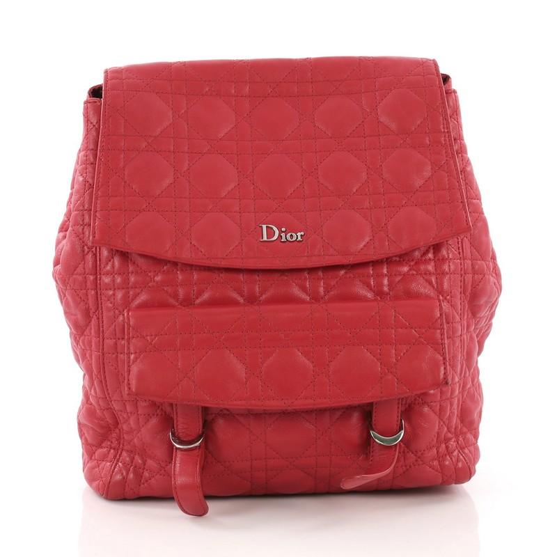 This Christian Dior Stardust Backpack Cannage Quilt Leather Large, crafted in red cannage quilted lambskin leather, features adjustable shoulder straps, button snap expandable sides, exterior front flap pocket with buckle closure and silver-tone