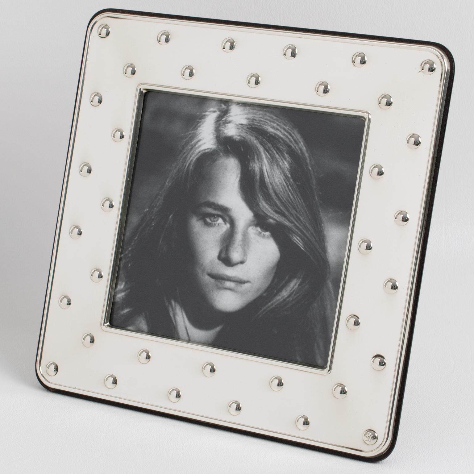 This lovely Christian Dior Paris sterling silver picture photo frame features a square shape with a geometric raised dots pattern. The back and easel are made in high gloss tropical wood. The piece is engraved on the edge with the 