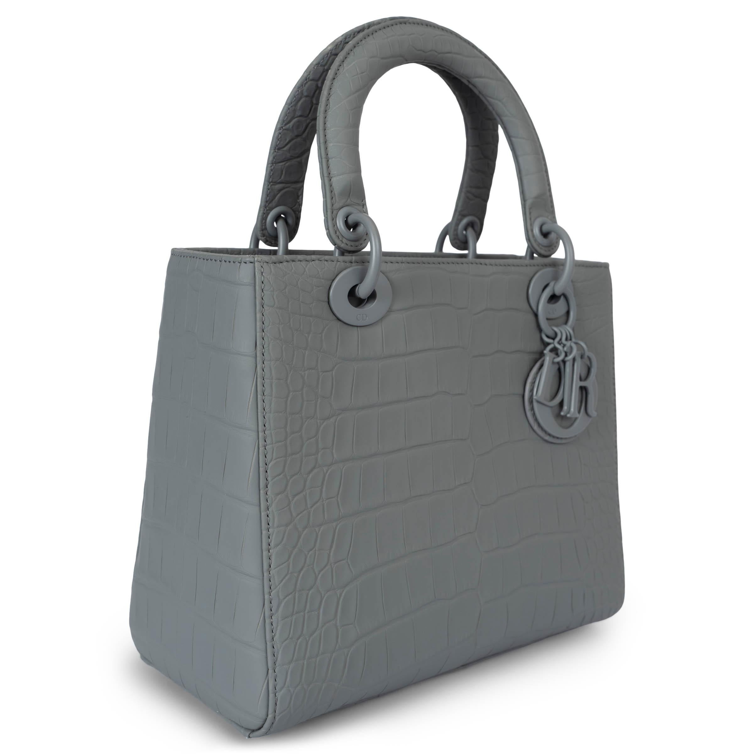 This 100% authentic Christian Dior Medium Lady Dior bag in Grey Stone Ultramatte Crocodile is a stunning example of timeless elegance and luxury craftsmanship. Beautifully crafted from luxurious alligator leather, this tote features reinforced