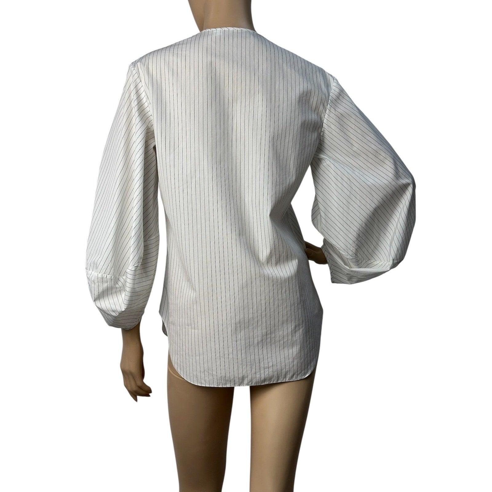 

Una camicia minimalista dal taglio dritto con sottili strisce verticali e maniche voluminose crea una silhouette equilibrata e aggiunge nitidezza grafica al look. Grazie al design pulito e alla tonalità versatile, questo pezzo si abbina facilmente