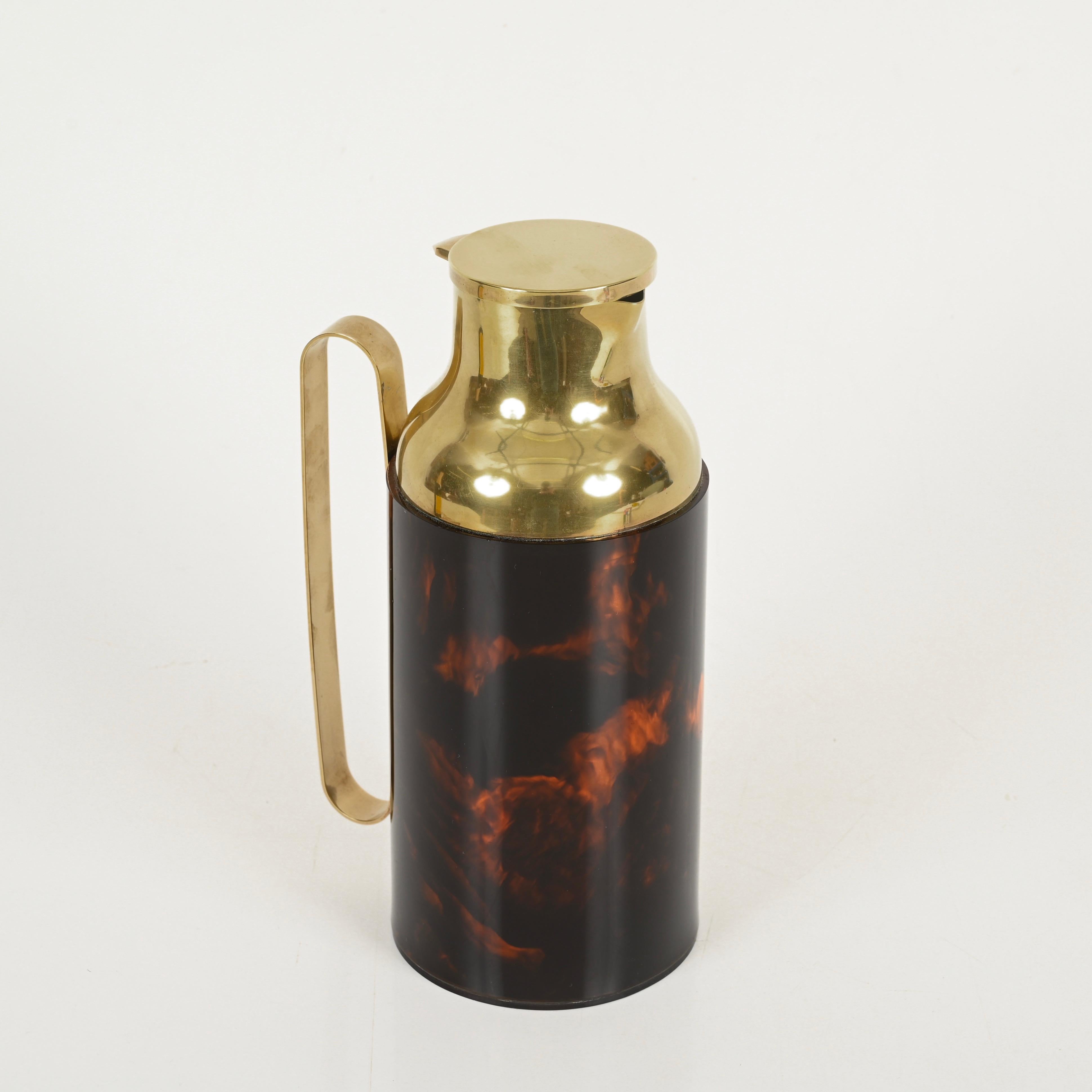 Splendida caraffa o thermos decorativo di metà secolo in lucite effetto tartaruga e ottone dorato. Questo pezzo incredibilmente elegante è attribuito a un disegno di Dior Home ed è stato realizzato in Italia negli anni Settanta. 

In condizioni