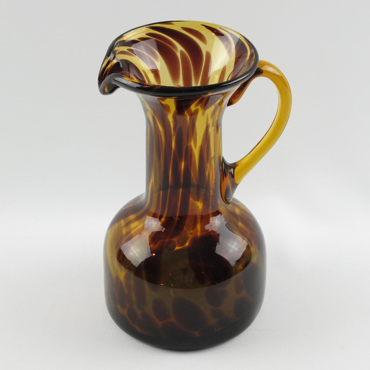 Elegant glass pitcher manufactured by Empoli, Italy for Christian Dior Home Collection. Mouth-blown with an exclusive tortoiseshell (tortoise) color flowing pattern. Polished pontil mark on the bottom.
Measurements: 5.50 in. wide (14 cm) x 4.12 in.