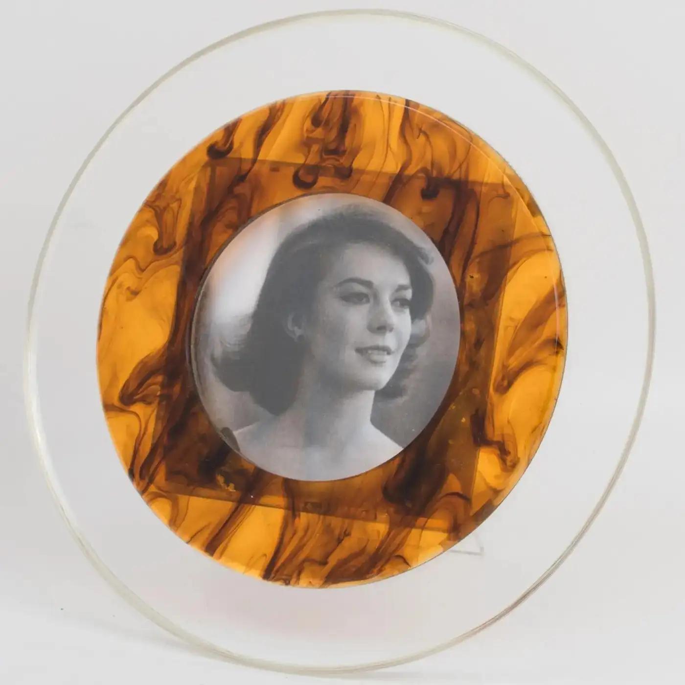 Christian Dior designed this stunning picture frame for his Christian Dior Home Collection in the 1970s. It is the perfect way to showcase your favorite photos. The frame has a rounded shape and a lovely combination of clear and tortoiseshell