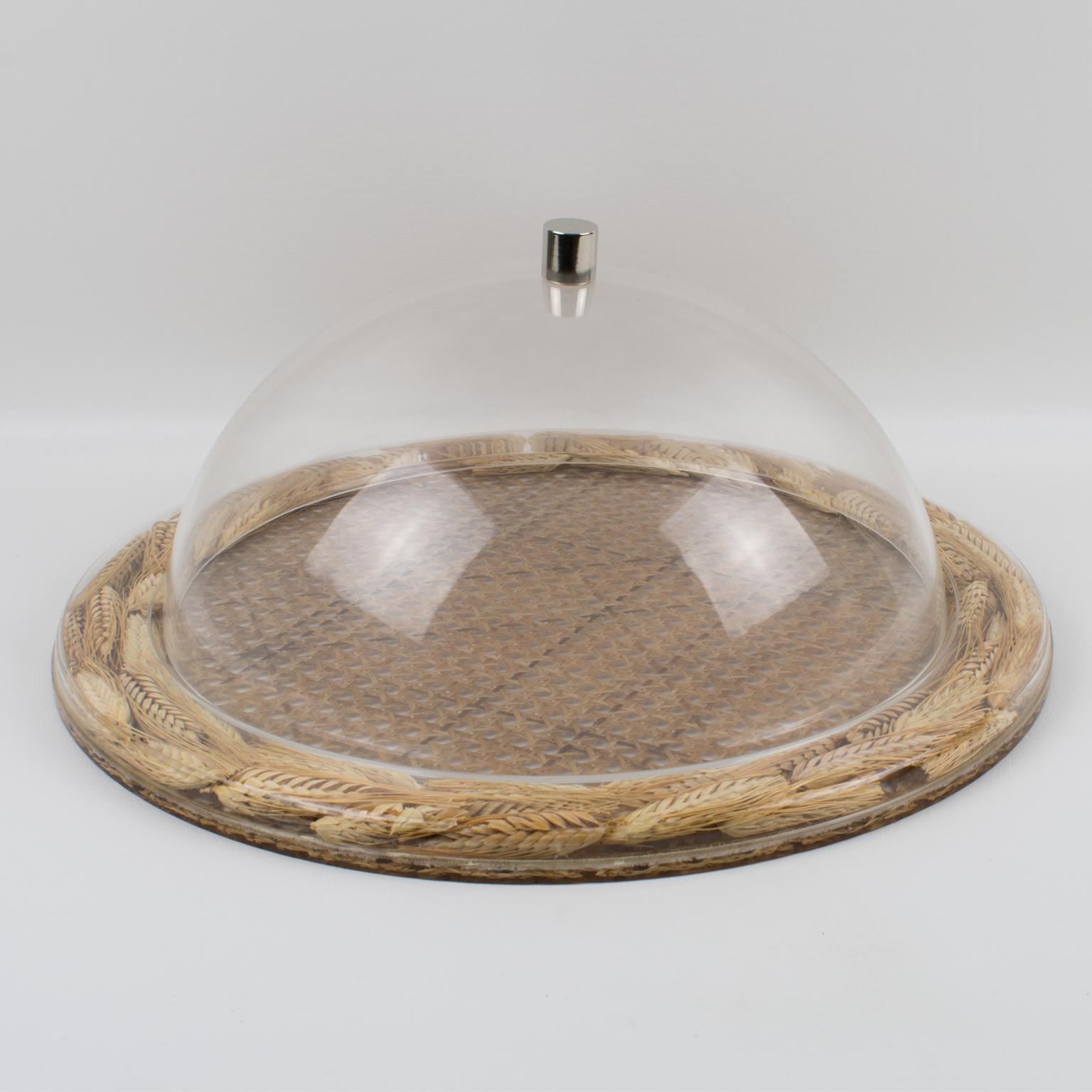 This is a very special and unique serving tray, designed by Christian Dior in the 1970s for his Home Collection. This board or platter has a rounded shape with raised edges. Made of clear Lucite or Plexiglass with real wheat and rattan cane work