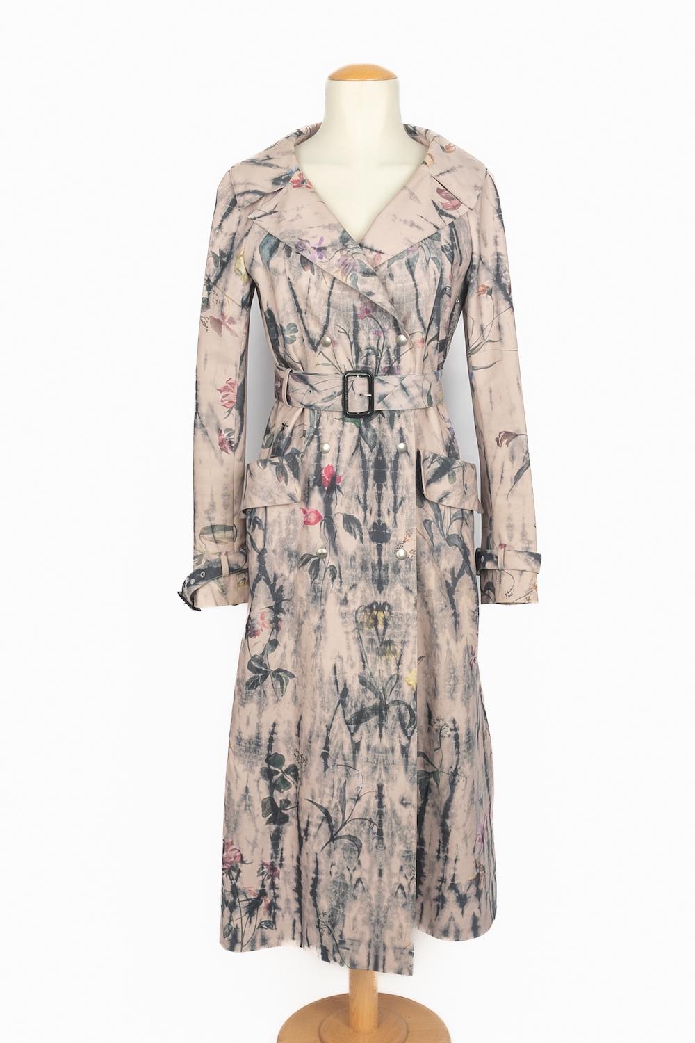 DIOR - (Fabriqué en Italie) Trench en coton délavé à fleurs bleu marine, roses et jaunes sur fond vieux rose. Intérieur imprimé d'un monogramme. Taille 40FR indiquée. Collectional printemps-été 2019 sous la direction artistique de Maria Grazia