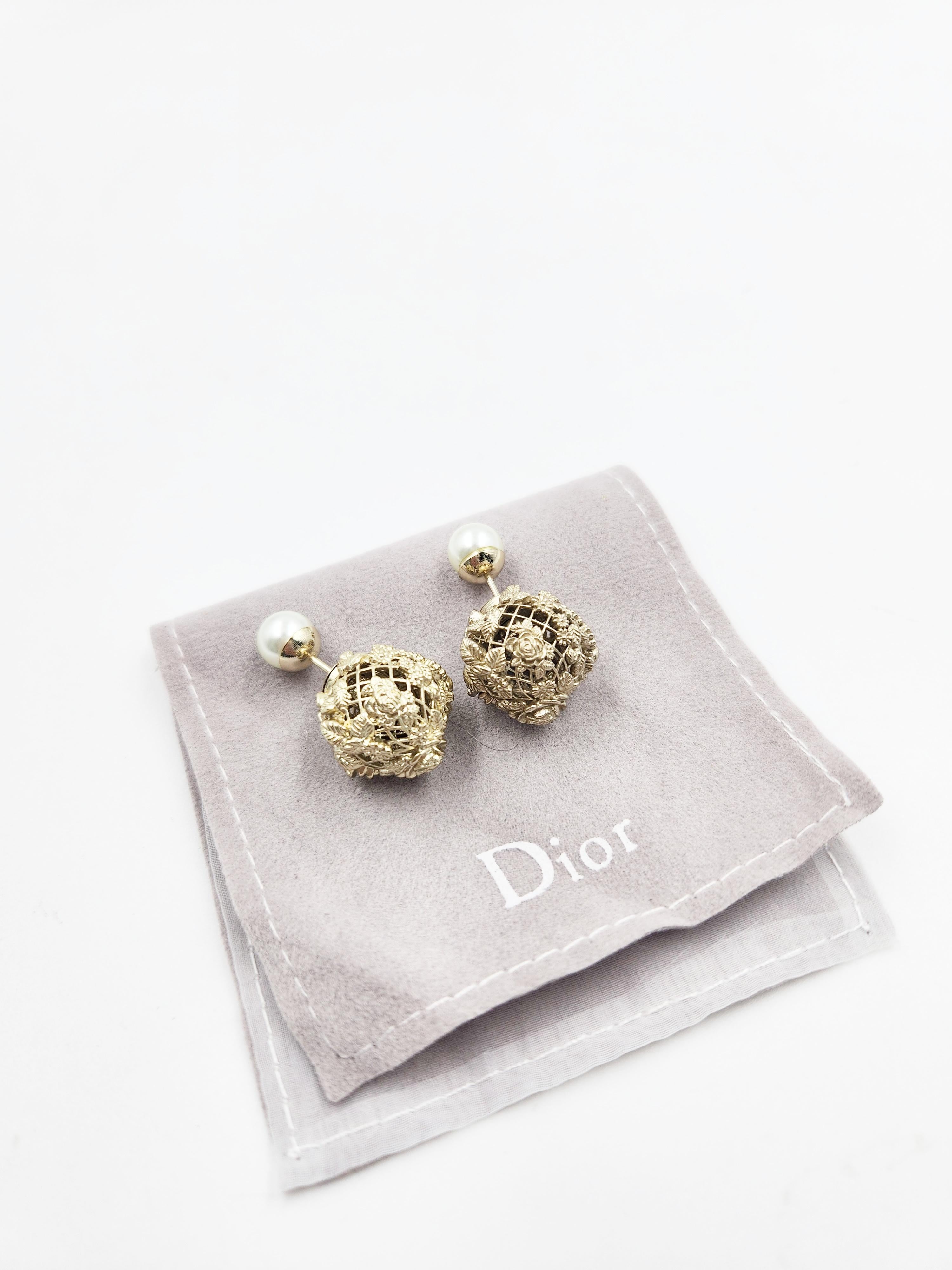 As seen at the fashion show, the Dior Tribales earrings reveal a floral inspiration in celebration of the collection's signature Andalusia theme. Hallmark resin pearls in the back reveal an openwork effect in gold-finish metal enhanced by a finely