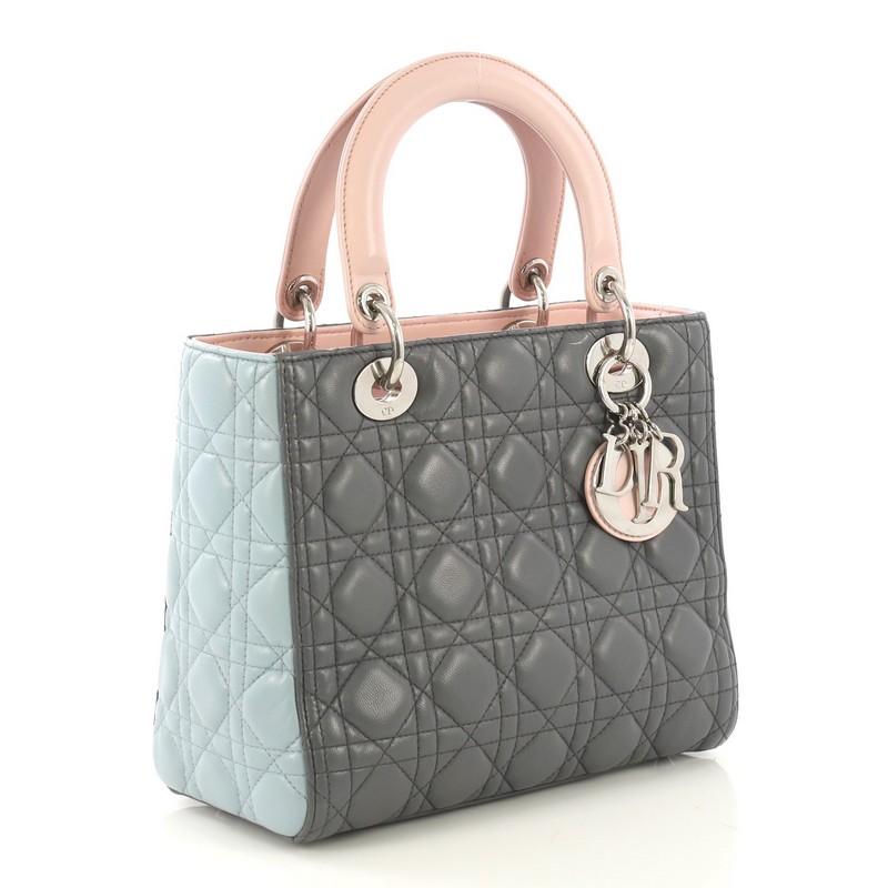 This Christian Dior Tricolor Lady Dior Handbag Cannage Quilt Leather Medium, crafted in multicolor cannage quilt leather, features dual top leather handles, Dior charms, protective base studs, and silver-tone hardware. Its zip closure opens to a