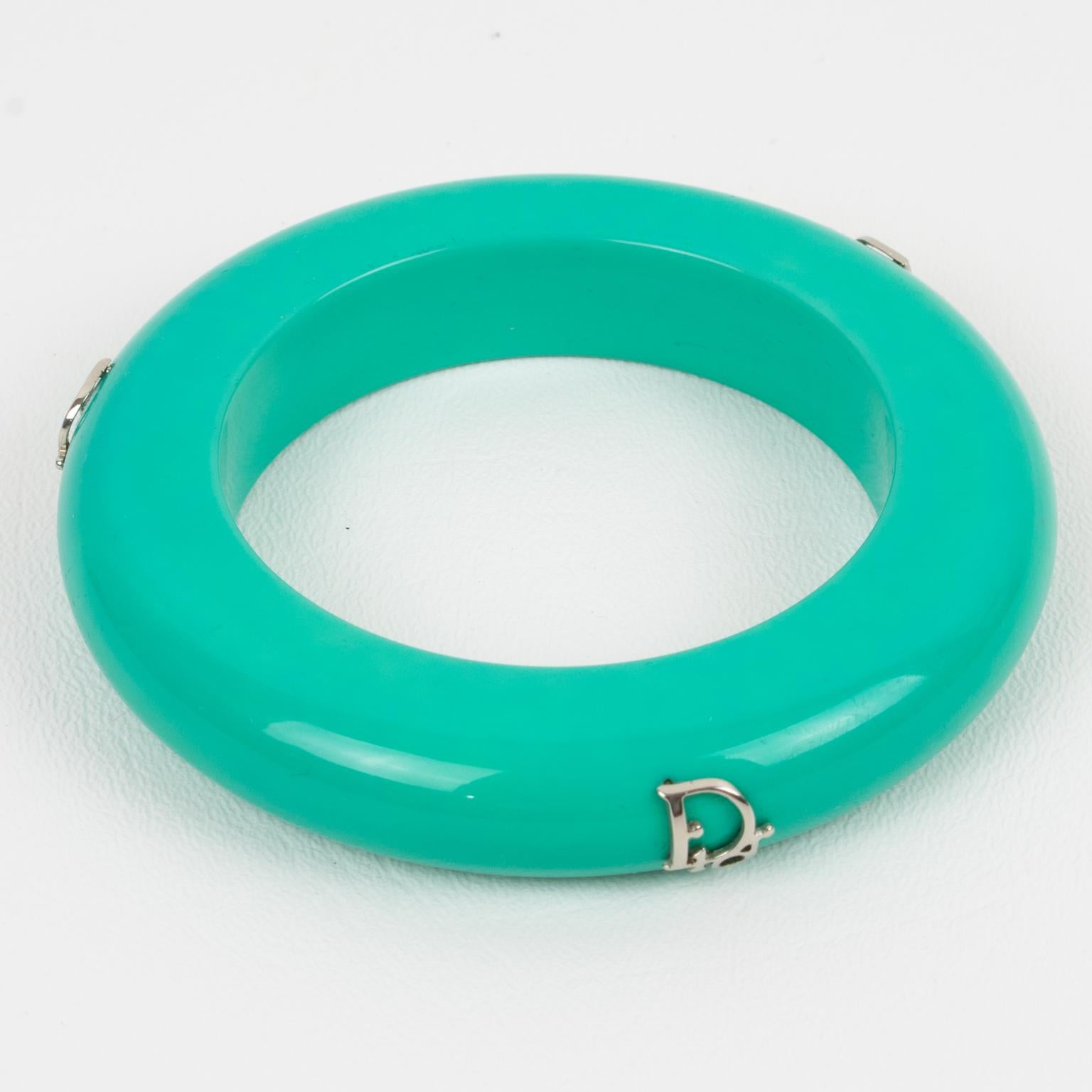 This exquisite bangle bracelet by Christian Dior features a stunning turquoise hue and is embellished with three striking silver 