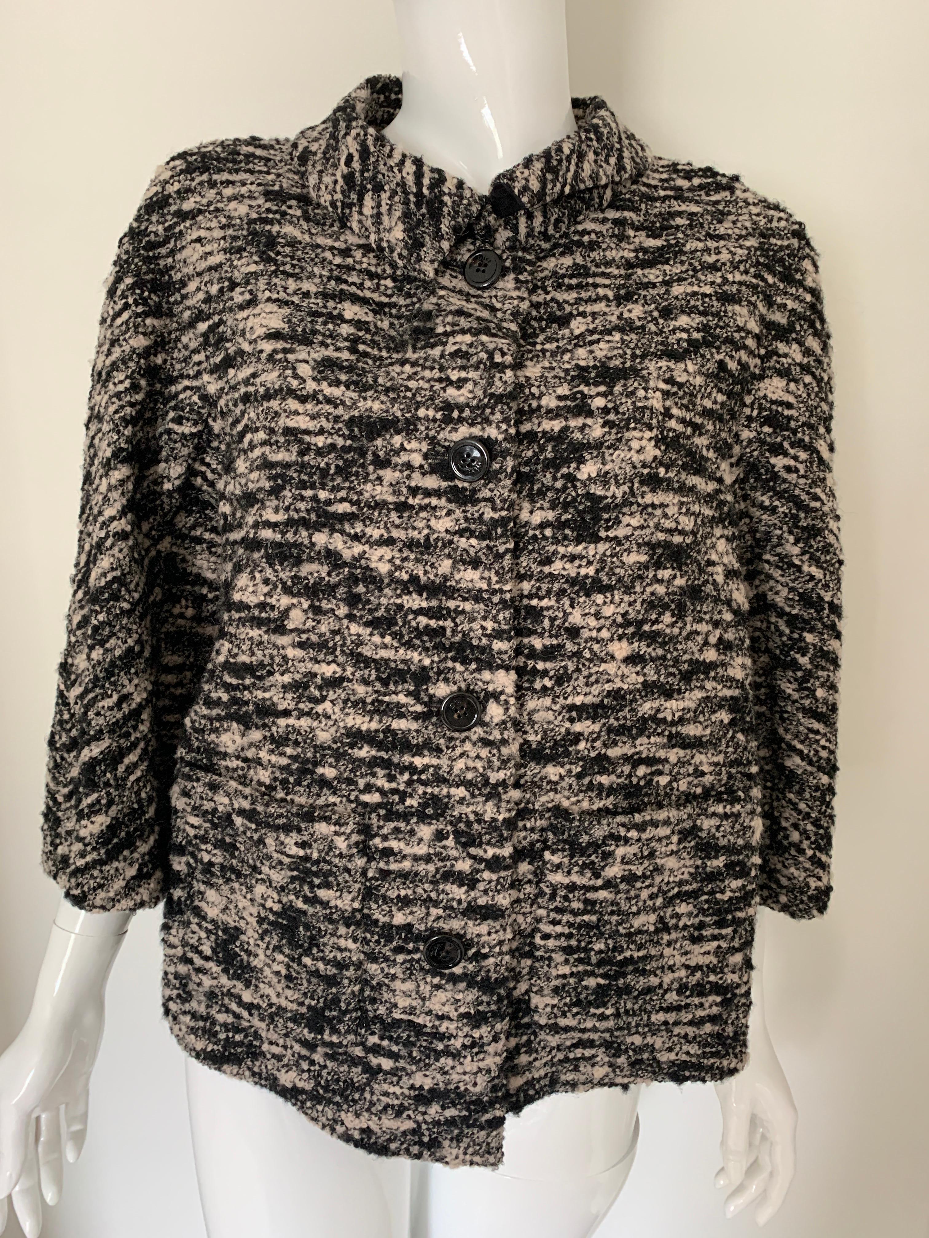 Christian Dior tweed waist jacket. 
Black and cream tweed with black buttons. 
Slight swing shape, ending just below the waist and sleeves hitting wrists. 
Black silk lined. 
US size 4. 
Excellent condition. 