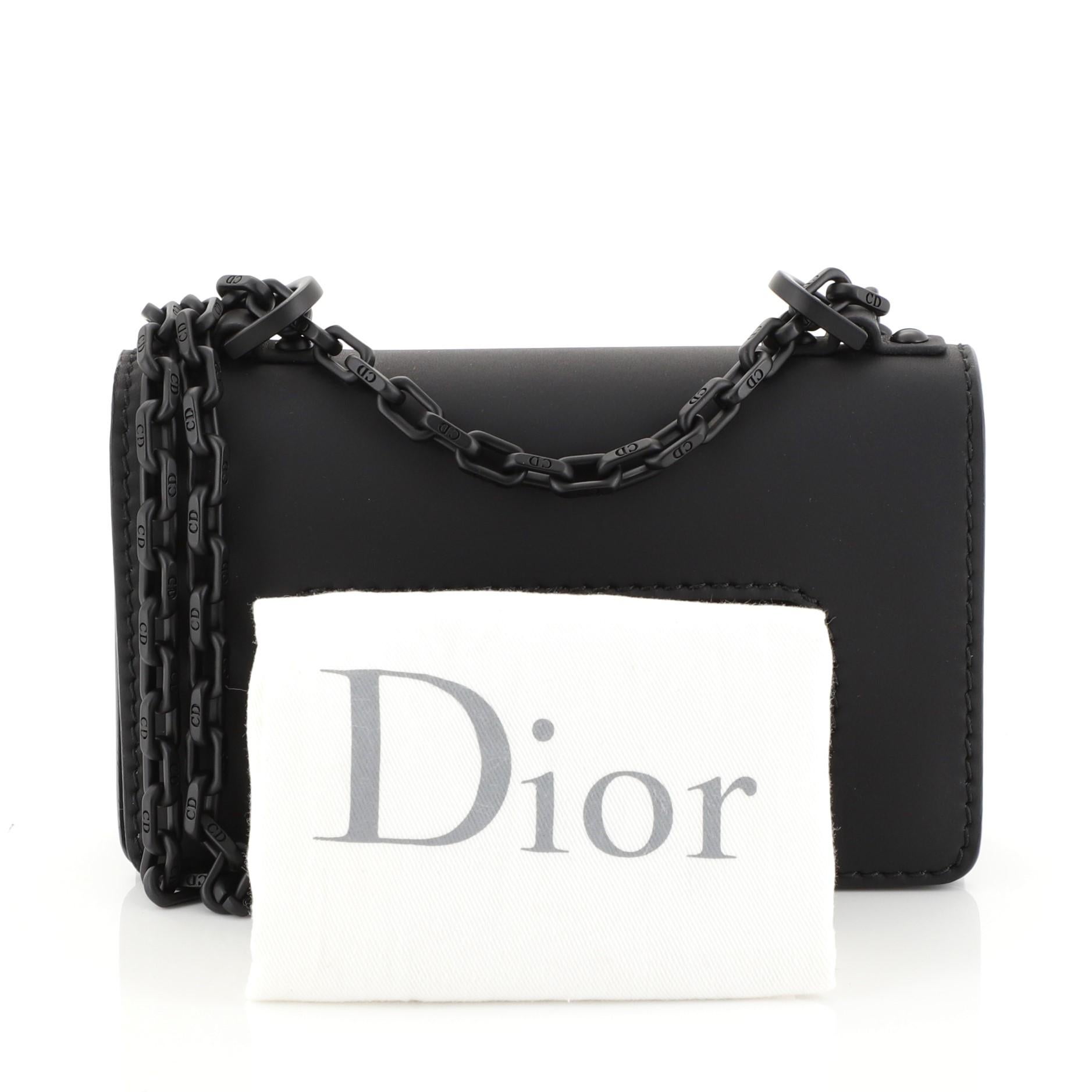 This Christian Dior Ultra Matte J'adior Flap Bag Matte Calfskin Mini, crafted from black calfskin leather, features chain link strap, slot handclasp, and matte black-tone hardware. Its flap opens to a black microfiber interior with slip pocket.