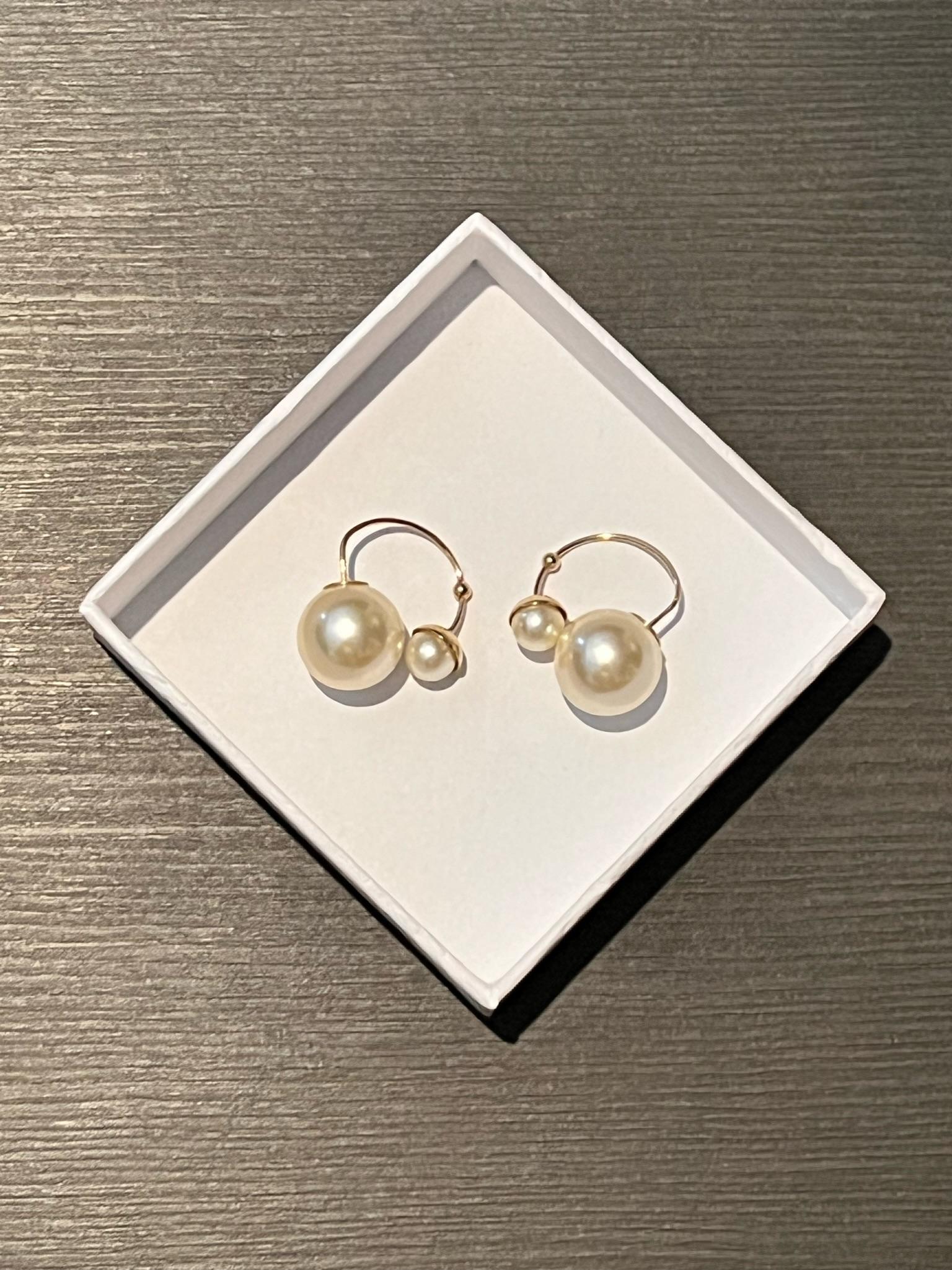 Uniquely designed in an open structured design, these 'Ultradior' earrings are a must-have.

Dior Ultradior Faux Pearl Gold Tone Half Hoop Earrings.

The perfect gift in original box.

It is made of a gold-tone metal featuring two faux pearl beads