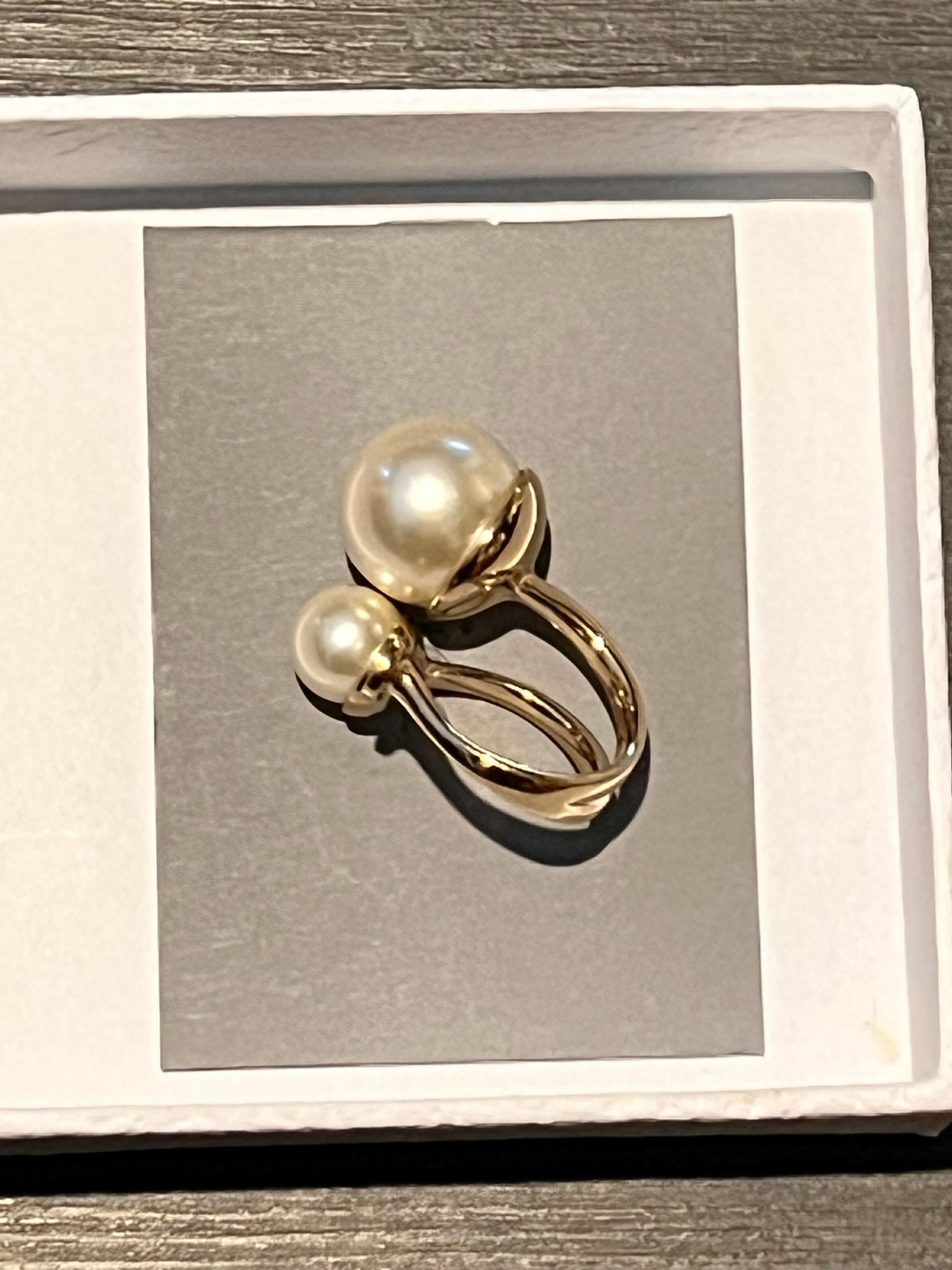 Uniquely designed in an open structured silhouette, this 'Ultradior' ring is a must-have.

It is made of a gold-tone metal featuring two faux pearl beads on one end and a stamped 'CD' logo on the other. 

Matching Earrings available.

Comes with