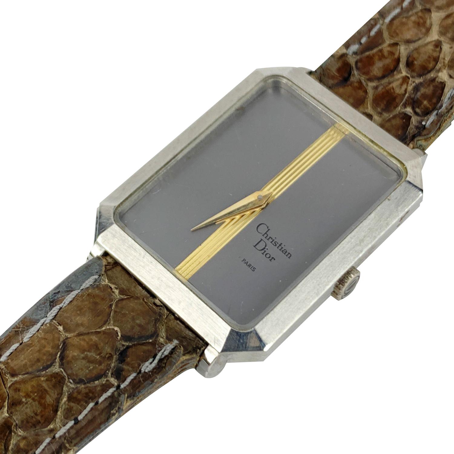 Vintage Christian Dior stainless steel wrist watch. Model 7836 - 131004. Stainless steel case. Automatic movement. Gray dial with gold stripe. Brown leather strap. CD buckle. Measurements: Adjustable shoulder strap. Max circumference: 8 inches -