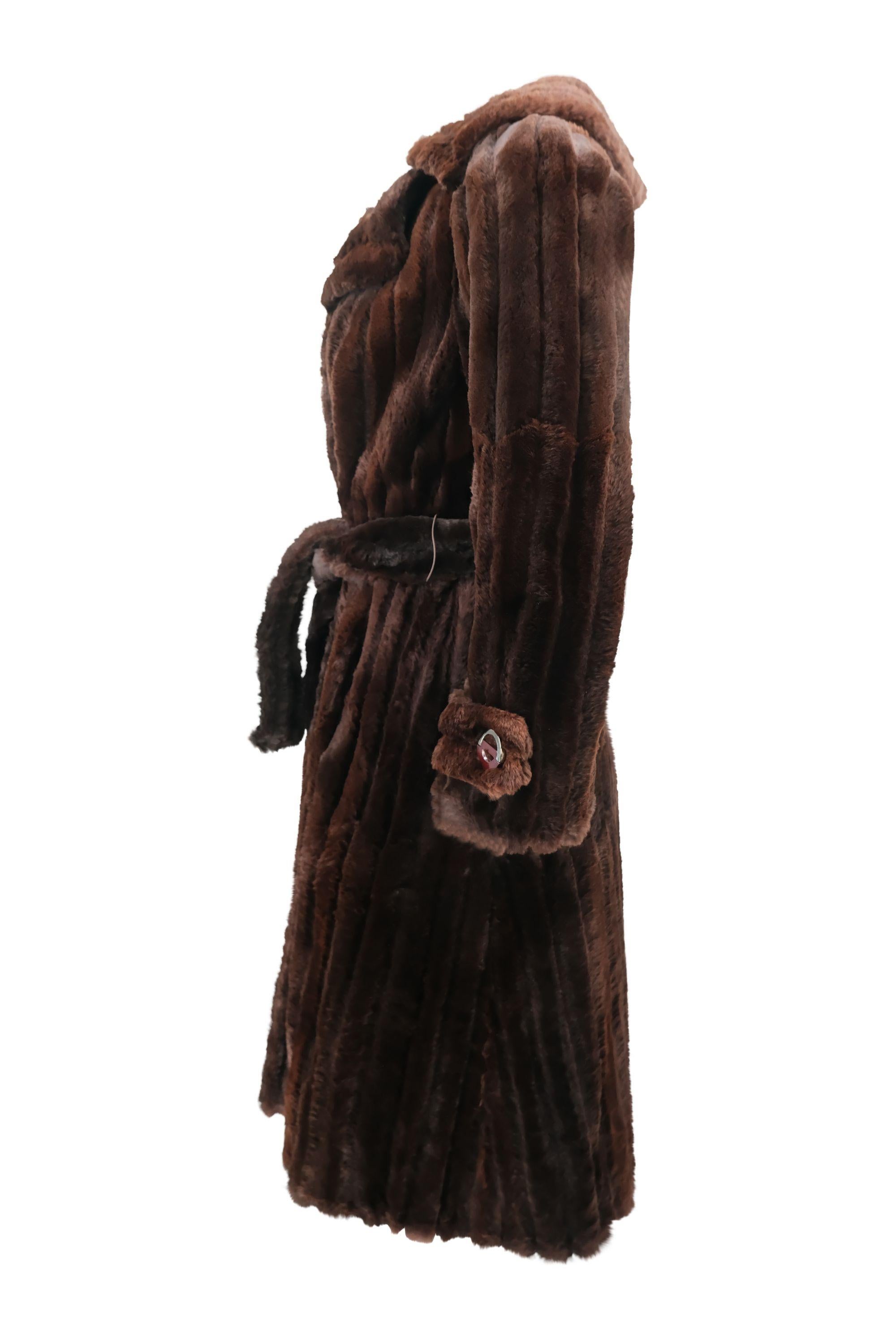 This vintage Dior mink fur coat is pure 1970's glam. The coat features a deep, rich brown color with plush vertical stripes in the fur to create a ribbed effect. Designed with a wide, sophisticated collar and a waist-cinching belt, the piece