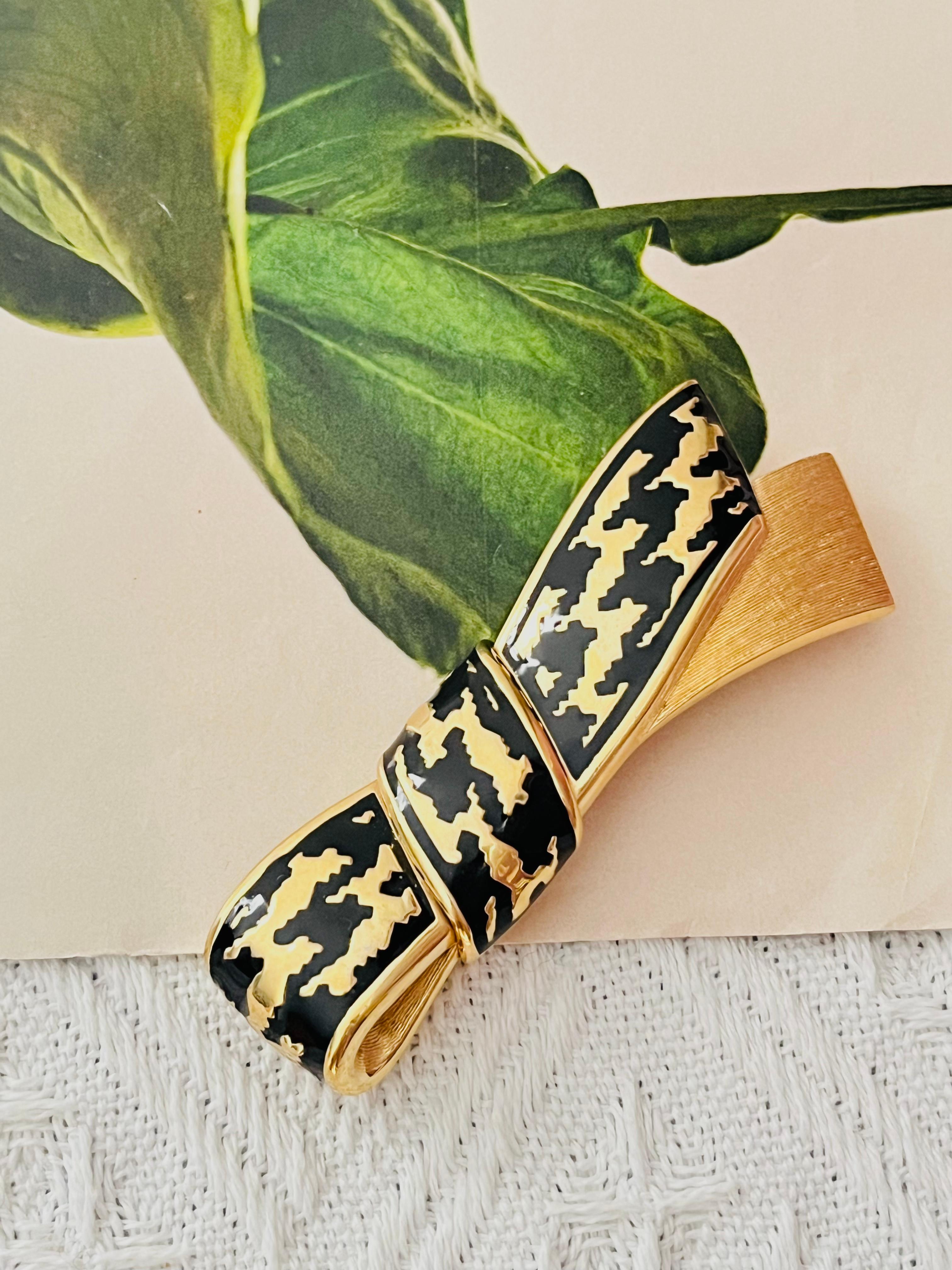 Christian Dior Vintage 1980s Unisex Large Long Black Enamel Ripple Knot Bow Ribbon Chunky Modernist Brooch, Gold Tone

Very excellent condition. 100% genuine. 

A unique piece. This is gold plated stylised brooch. Safety-catch pin closure. 

Size: