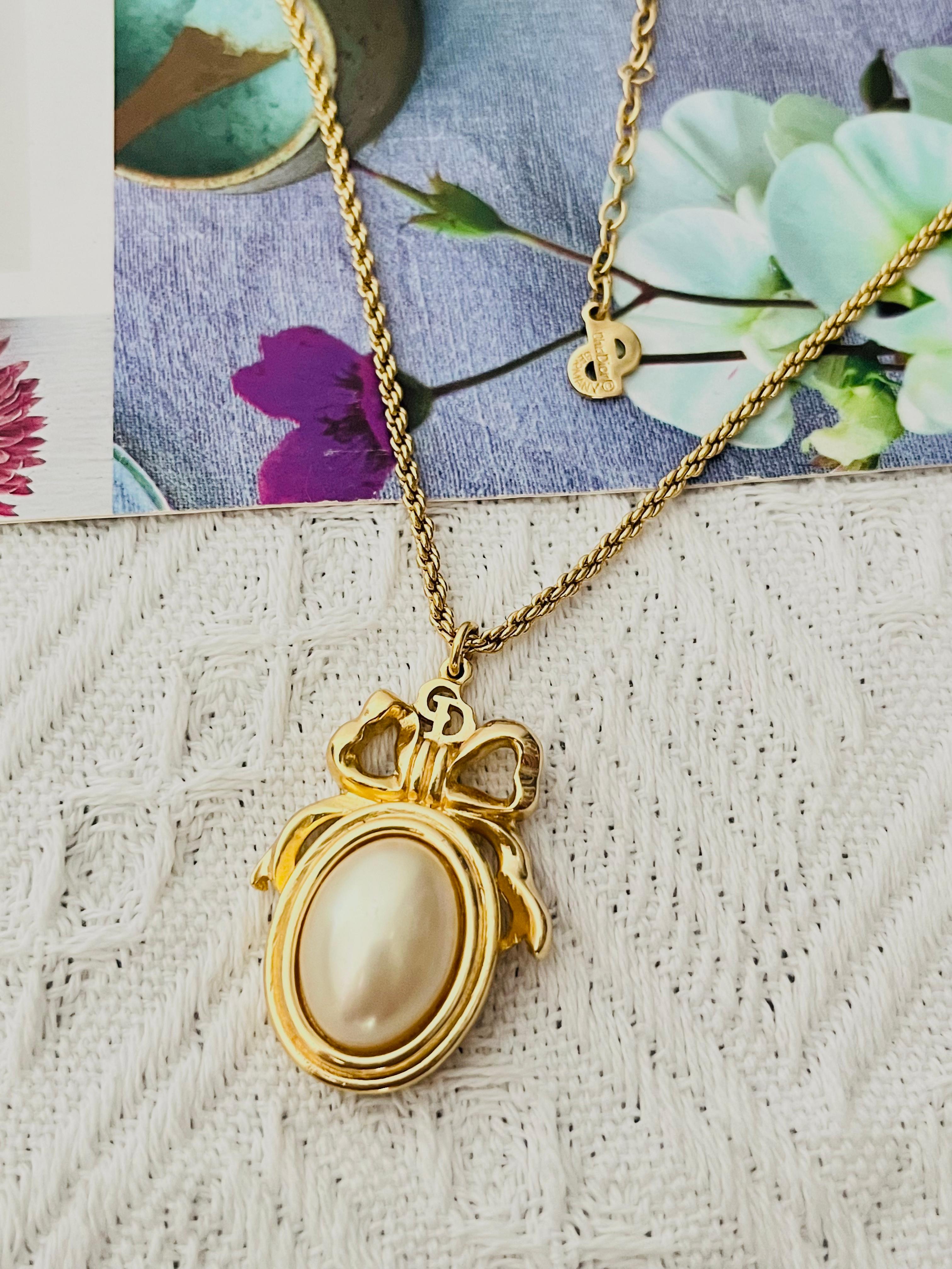 Christian Dior Vintage 1980s Classic Iconic Large Logo CD Knot Bow Ribbon Oval White Pearl Pendant Elegant Necklace, Gold Plated

Very excellent condition. Very new. 100% Genuine.  Rare to find. Marked 'Chr.Dior (C) '.

It is around 50 years old.