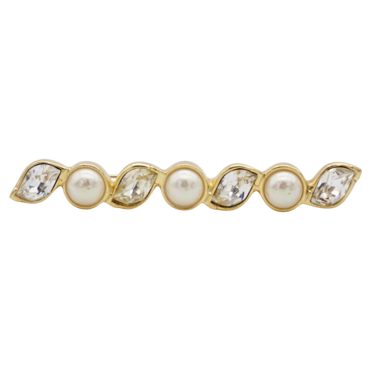 Christian Dior Vintage 1980s Long Bar Leaf Shining Crystals White Pearls Brooch, Gold Tone

Renowned for its timeless elegant designs, Christian Dior presents this brooch. Crafted from polished gold plated brass, the piece is adorned with dazzling