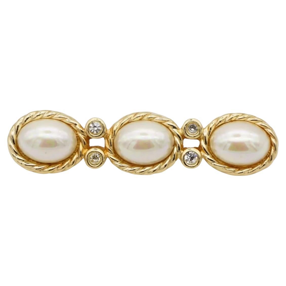 Christian Dior Vintage anni '80 Trio di perle ovali bianche e cristalli, spilla a barra lunga, tonalità oro

Rinomato per i suoi design eleganti e senza tempo, Christian Dior presenta questa spilla. Realizzato in ottone placcato oro lucido, il pezzo