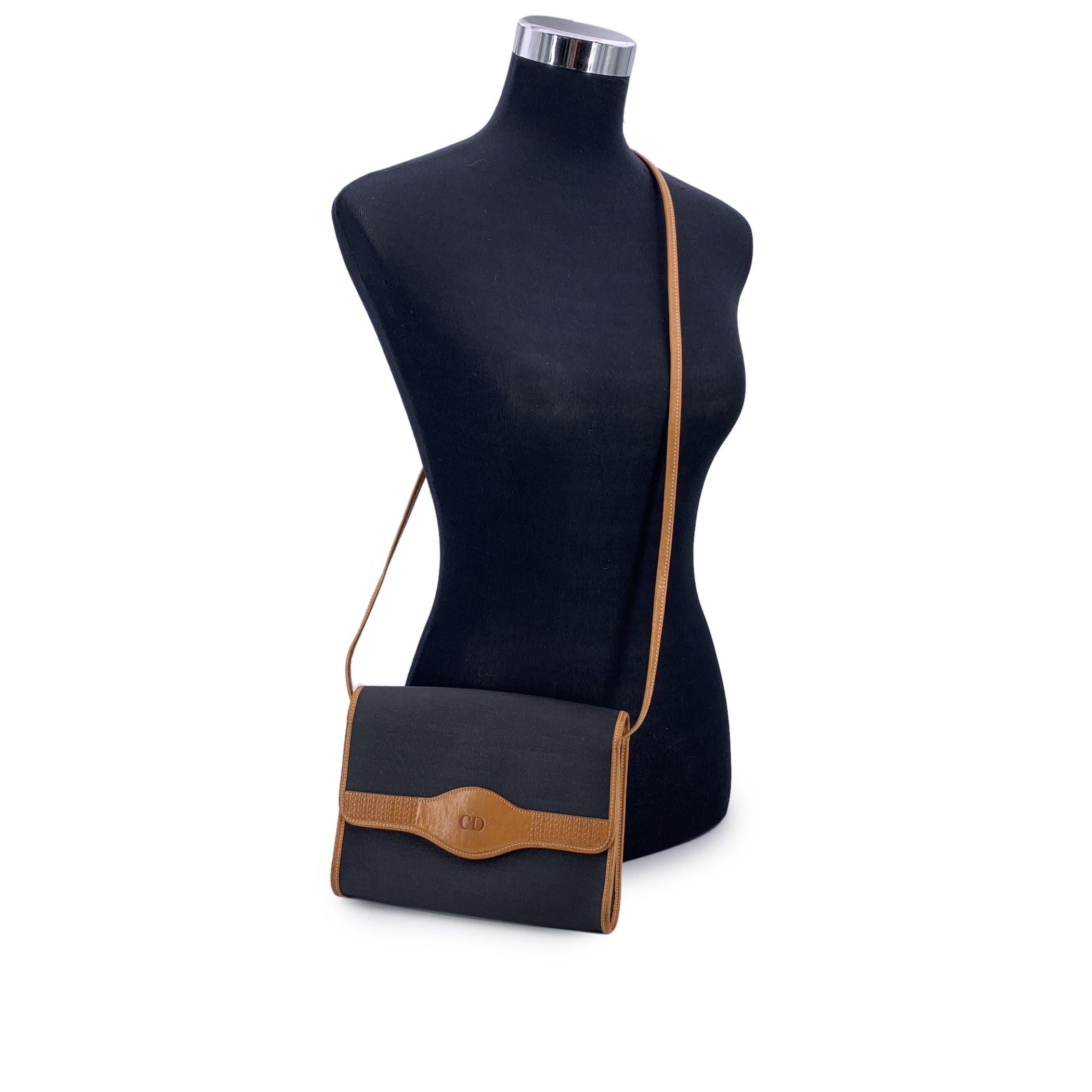 Pièce intemporelle de la maison Dior, ce sac à bandoulière vintage Christian Dior est un mélange raffiné d'élégance parisienne et de luxe discret. Confectionné en toile noire avec des bordures en cuir lisse, il possède le charme sans effort d'une
