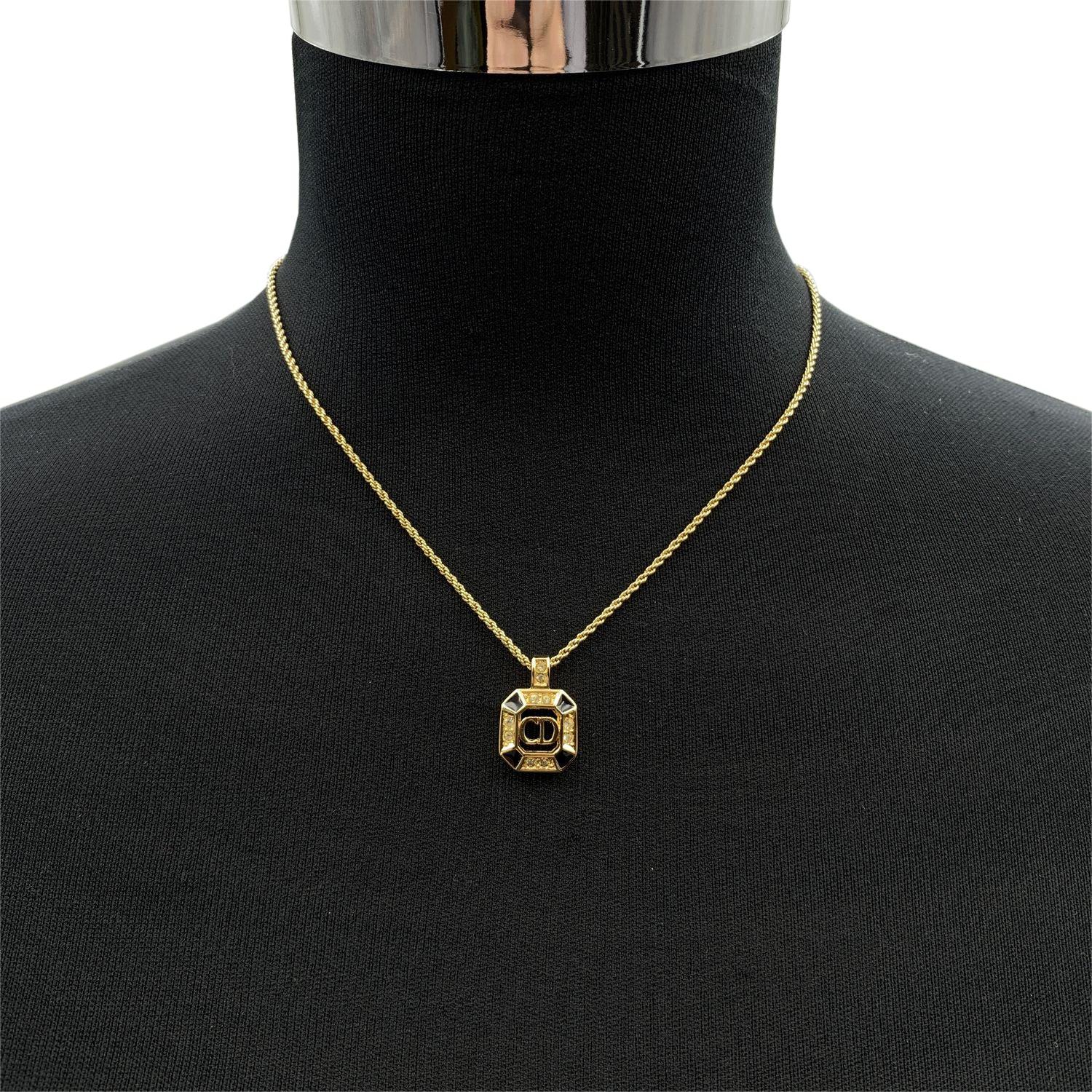 Collier vintage Christian Dior en chaîne de métal doré avec pendentif logo CD carré, agrémenté de petits strass et d'émail noir. Fermeture par anneau à ressort. Longueur de la chaîne : environ 16.5 inches - 42 cm Condition A - EXCELLENT Utilisé avec