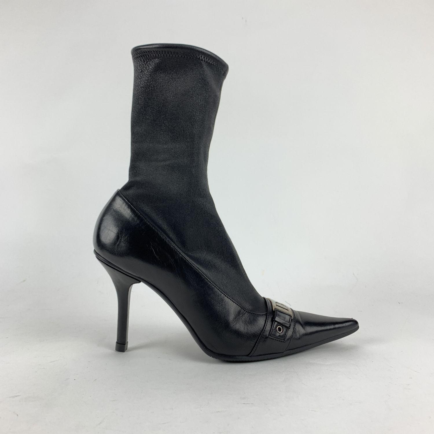 Christian Dior sock boots crafted from stretchy black leather that gently hugs your foot and ankle. Stiletto heels. Pointed toe. Silver metal cut-out logo buckle on the toes. Heels height: 4 inches - 10,2 cm.  Made in Italy.  Size is not indicated.