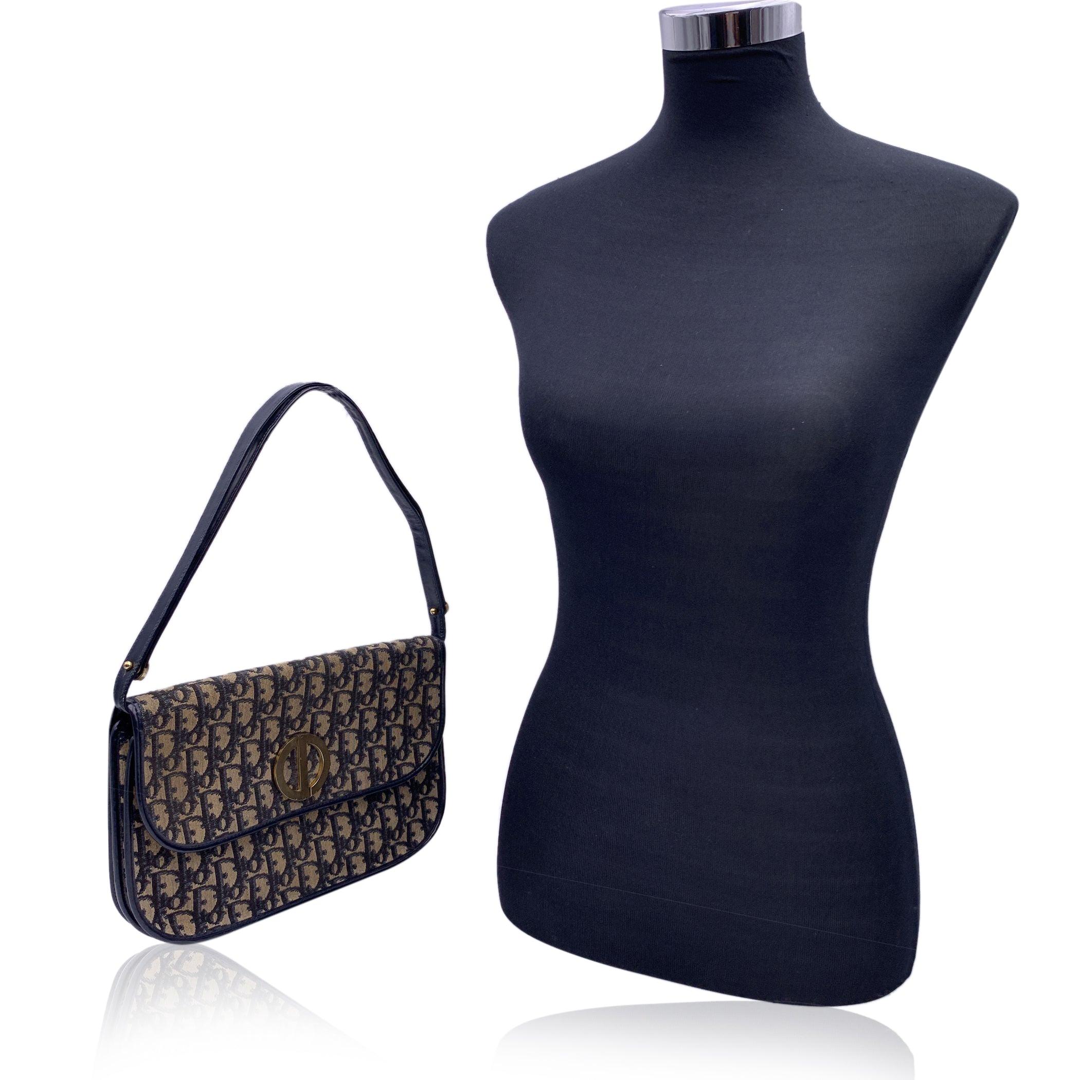 Vintage CHRISTIAN DIOR shoulder bag crafted in black monogram oblique canvas with black genuine leather trim. Flap with button closure . Black leather lining. 2 main sections inside. 1 side open pocket inside. Adjustable shoulder strap in 2 lenght.
