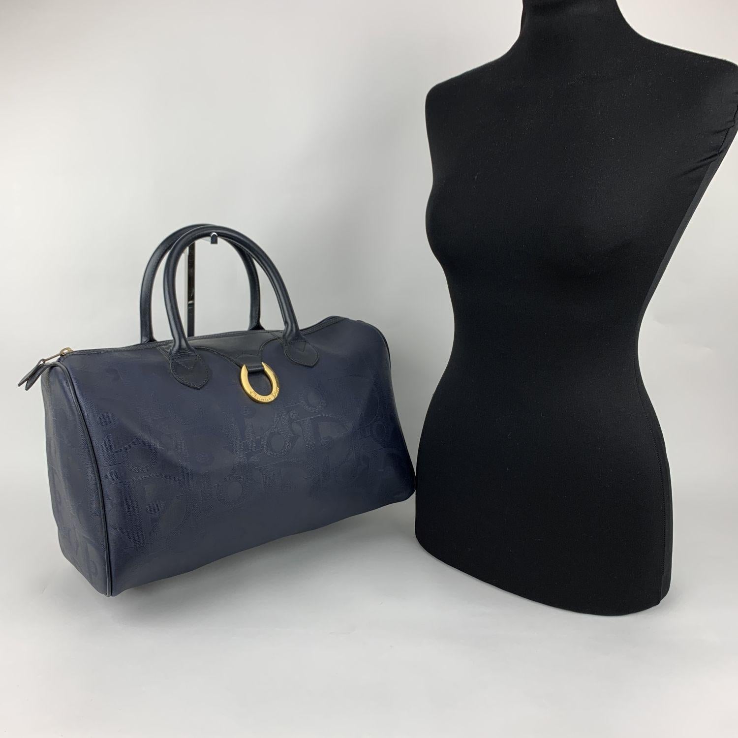 Vintage duffle boston bag by Christian Dior. Big Dior monogram pattern in blue color. Gold metal ring with Dior signature on the front. Upper zipper closure. Top leather handles. Canvas lining with 1 side zip pocket inside. 'Christian Dior - Made in