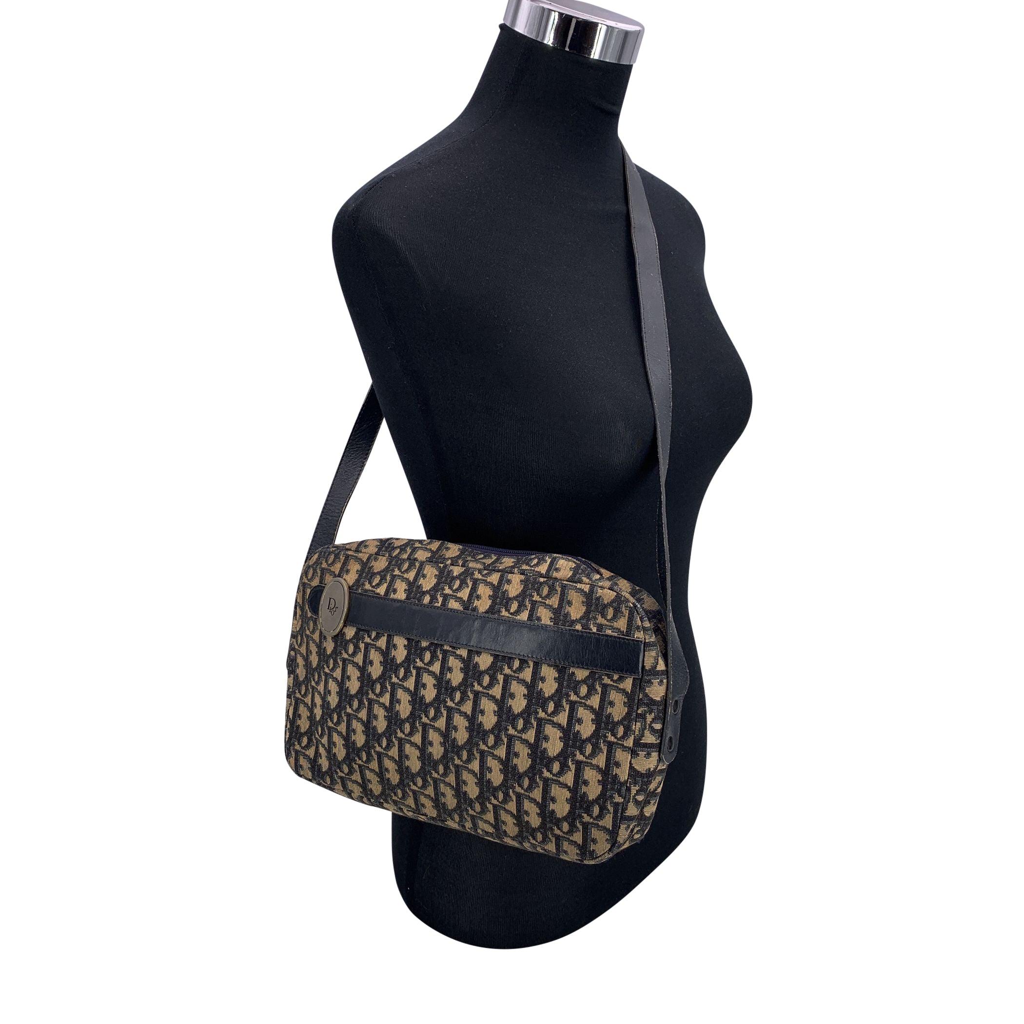 Vintage Christian Dior Shoulder Bag crafted from the house's iconic blue oblique monogram canvas with blue genuine leather trim. The design features an oval Dior tab on the front and an upper zipper closure that opens to a blue leather-lined