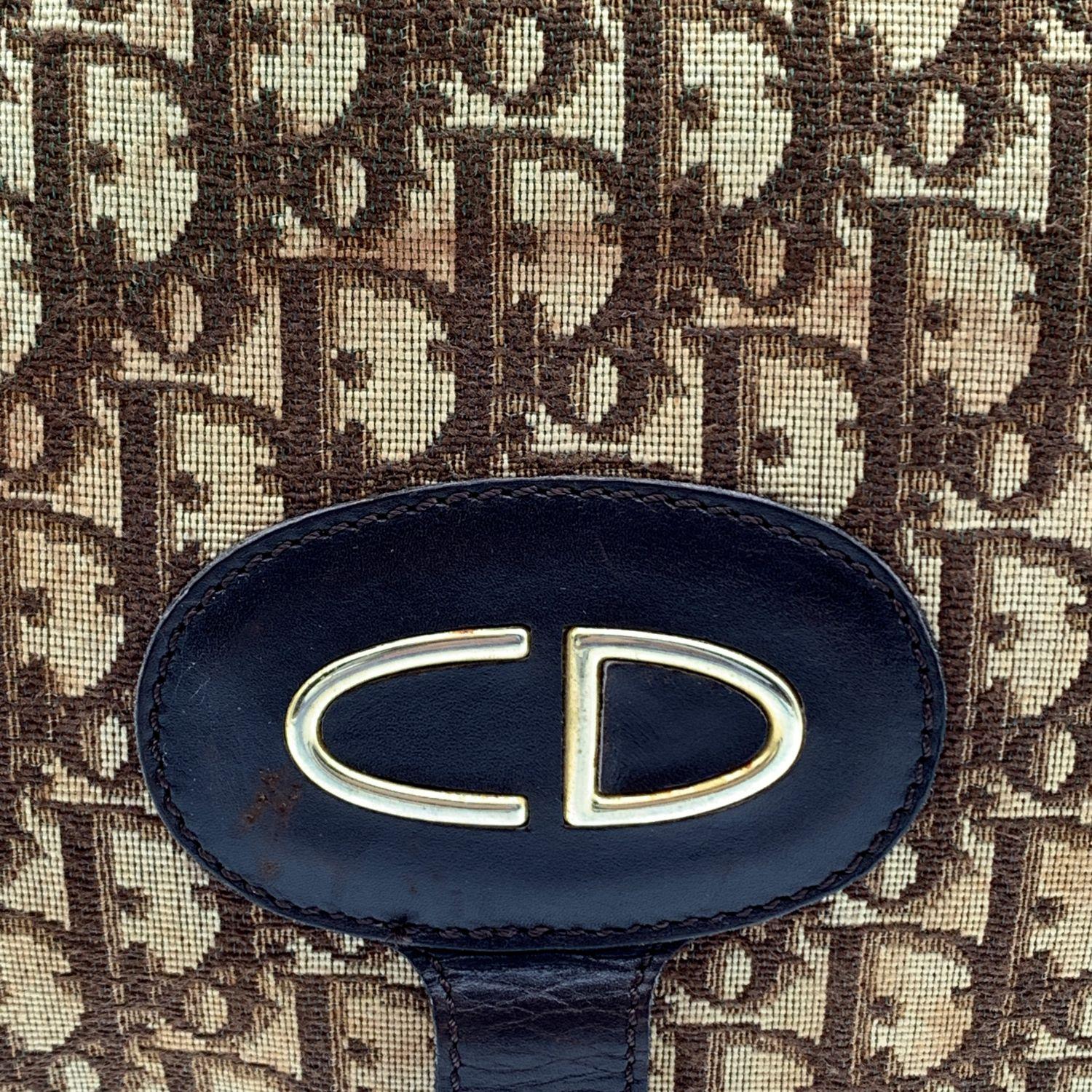 Christian Dior Vintage foldable clutch bag. Crafted in brown logo tapestry canvas with brown leather trim. Button closure on the front when it is fold. Multi-purpose design since this can be folded and carried as a clutch, or opened and used as a
