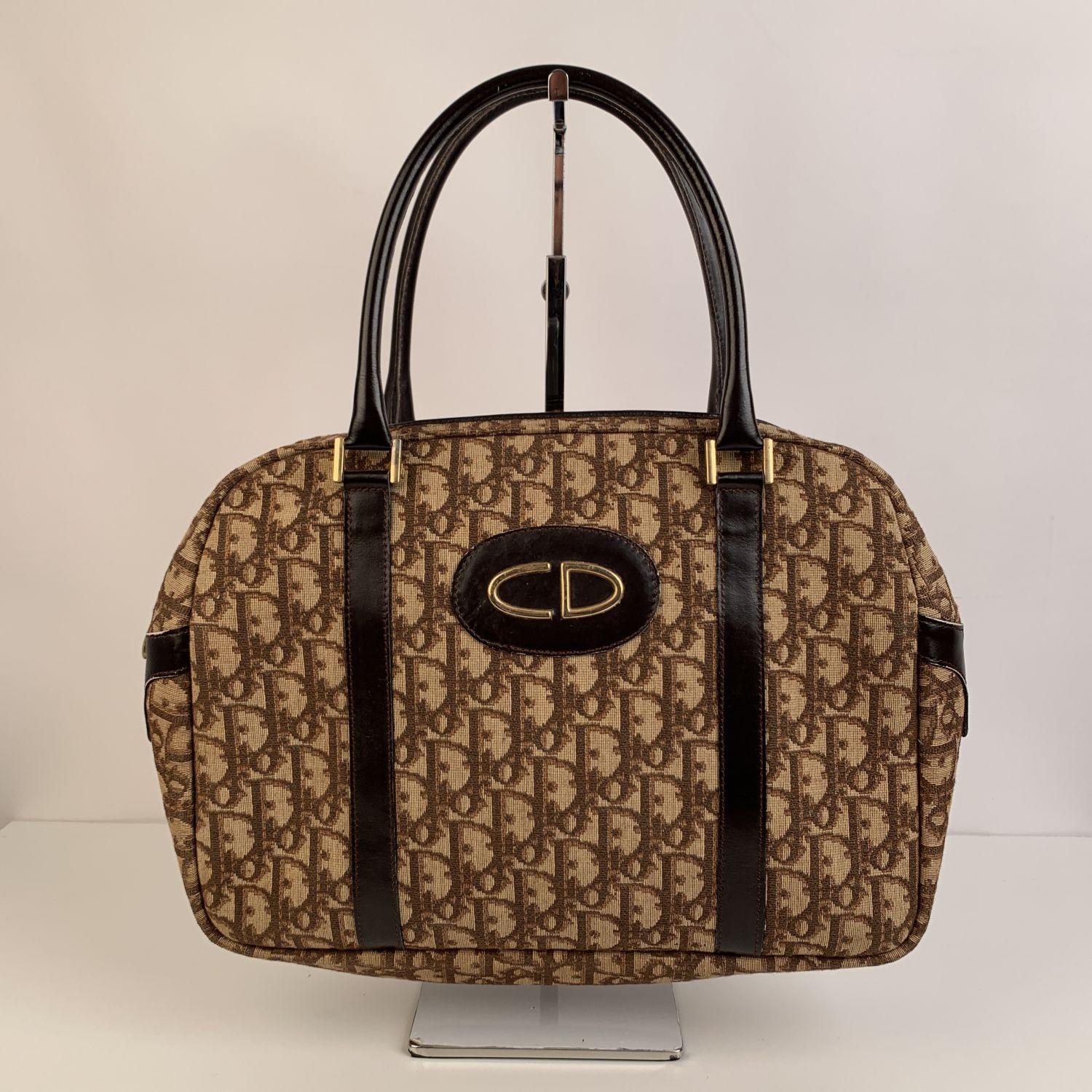 Vintage CHRISTIAN DIOR satchel bag crafted in brown tapestry monogram 'Diorissimo' canvas with dark brown genuine leather trim. Upper zipper closure. Brown leather lining. 2 side open pockets inside. 'CHRISTIAN DIOR - Made in France' embossed
