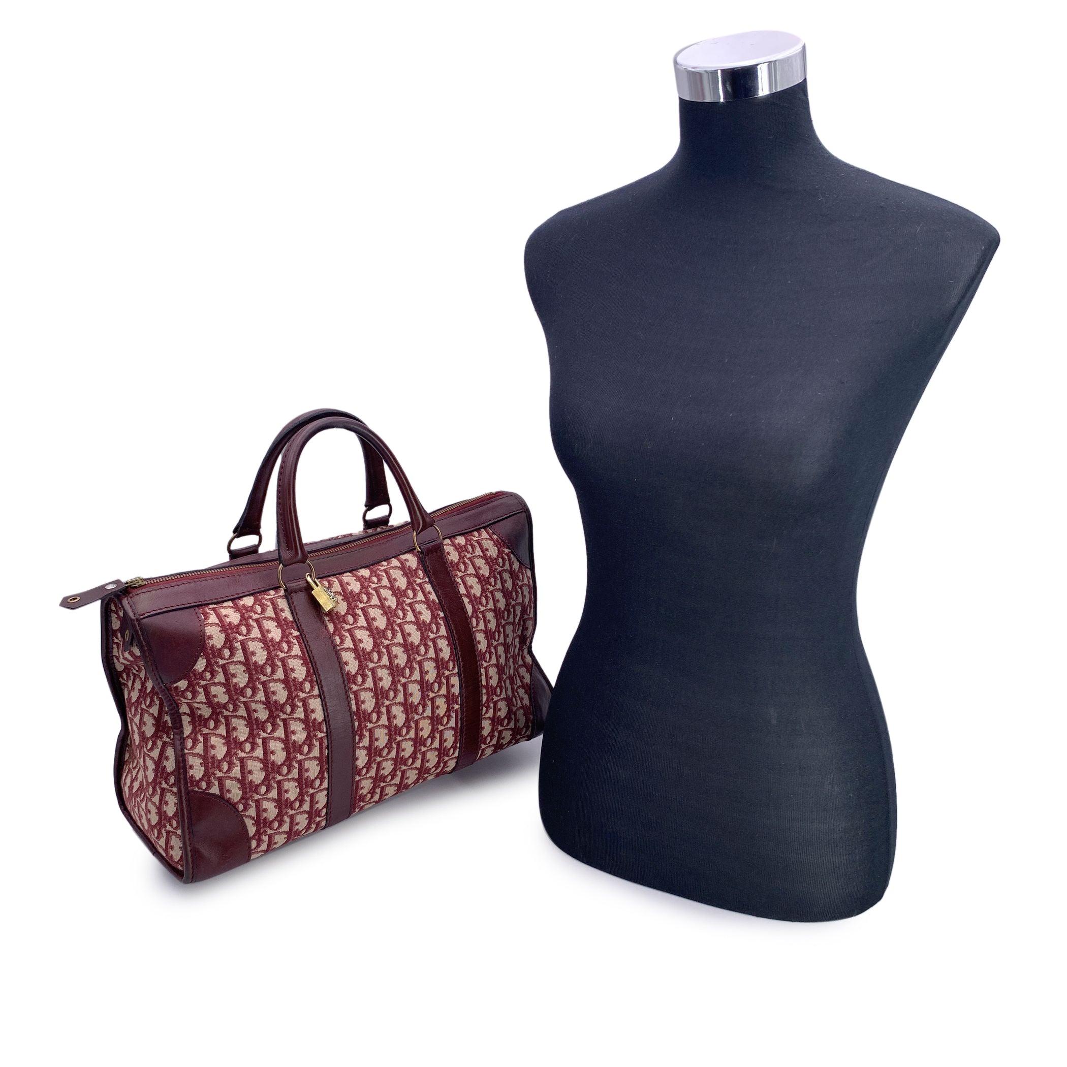 Discover the allure of vintage luxury with this exquisite CHRISTIAN DIOR satchel bag, a perfect blend of timeless design and sophisticated craftsmanship. This stunning piece is crafted in the iconic burgundy oblique monogram 'Diorissimo' canvas, a