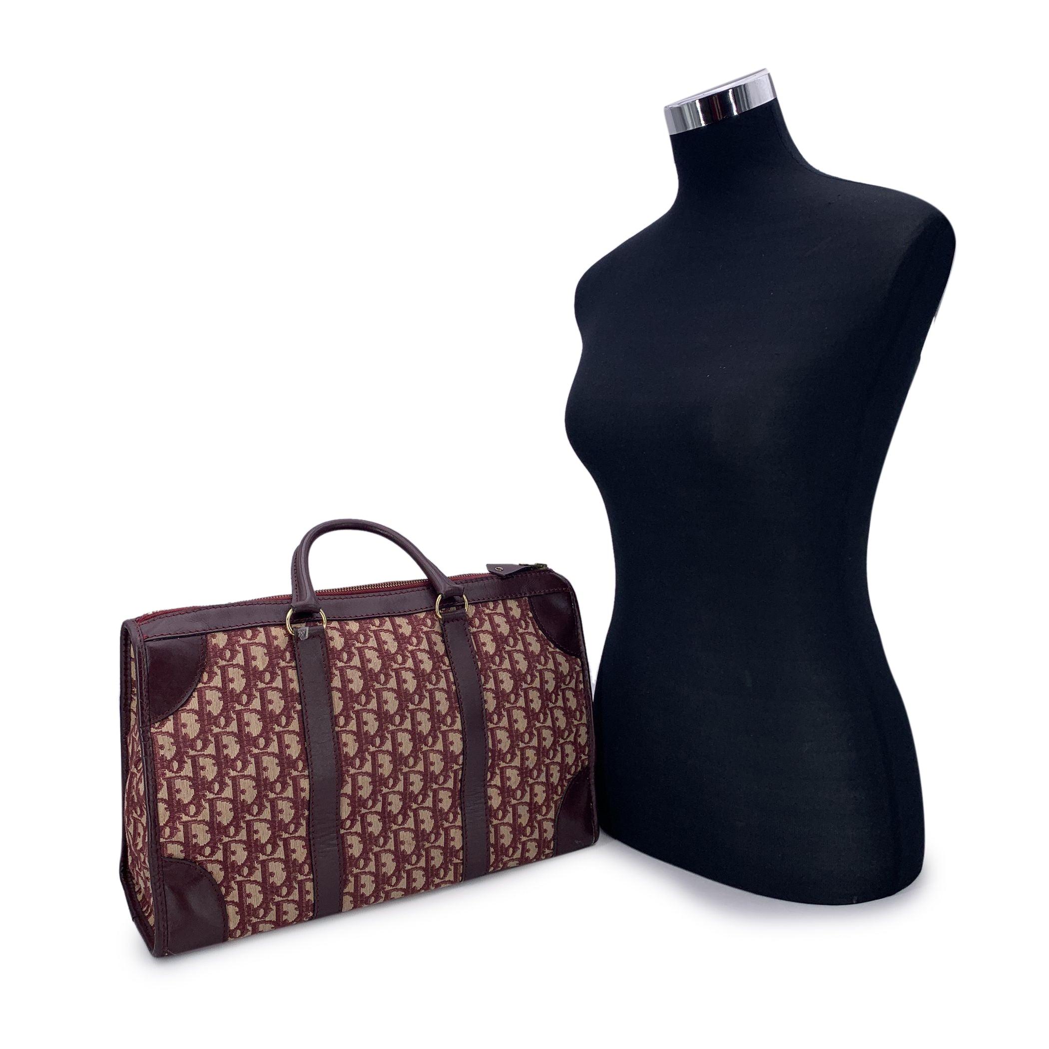 Vintage CHRISTIAN DIOR satchel bag crafted in burgundy oblique monogram 'Diorissimo' canvas with brown genuine leather trim. Upper zipper closure. Beige canvas lining. 1 side zip pocket inside. 'CHRISTIAN DIOR Bagages - Made in France' tag inside