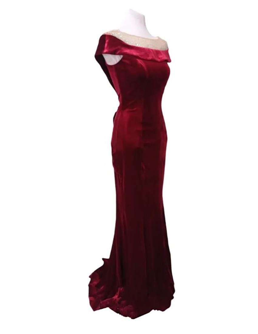 CHRISTIAN DIOR 

Vintage dress by Christian Dior in viscose and silk blend in shades of burgundy. 
 It has a tulle trim with small trinkets applied and has a bow on the back of the dress. 
 It has a length of about 61