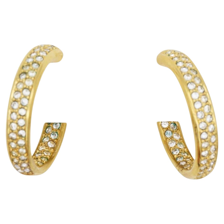 Christian Dior Vintage Circle Glow Open Hoop Crystals Huggie Pierced Earrings, Gold Tone.

Good condition. 100% Genuine. All stones are attached, but some darken or turn green. No original ears block.

Signed 